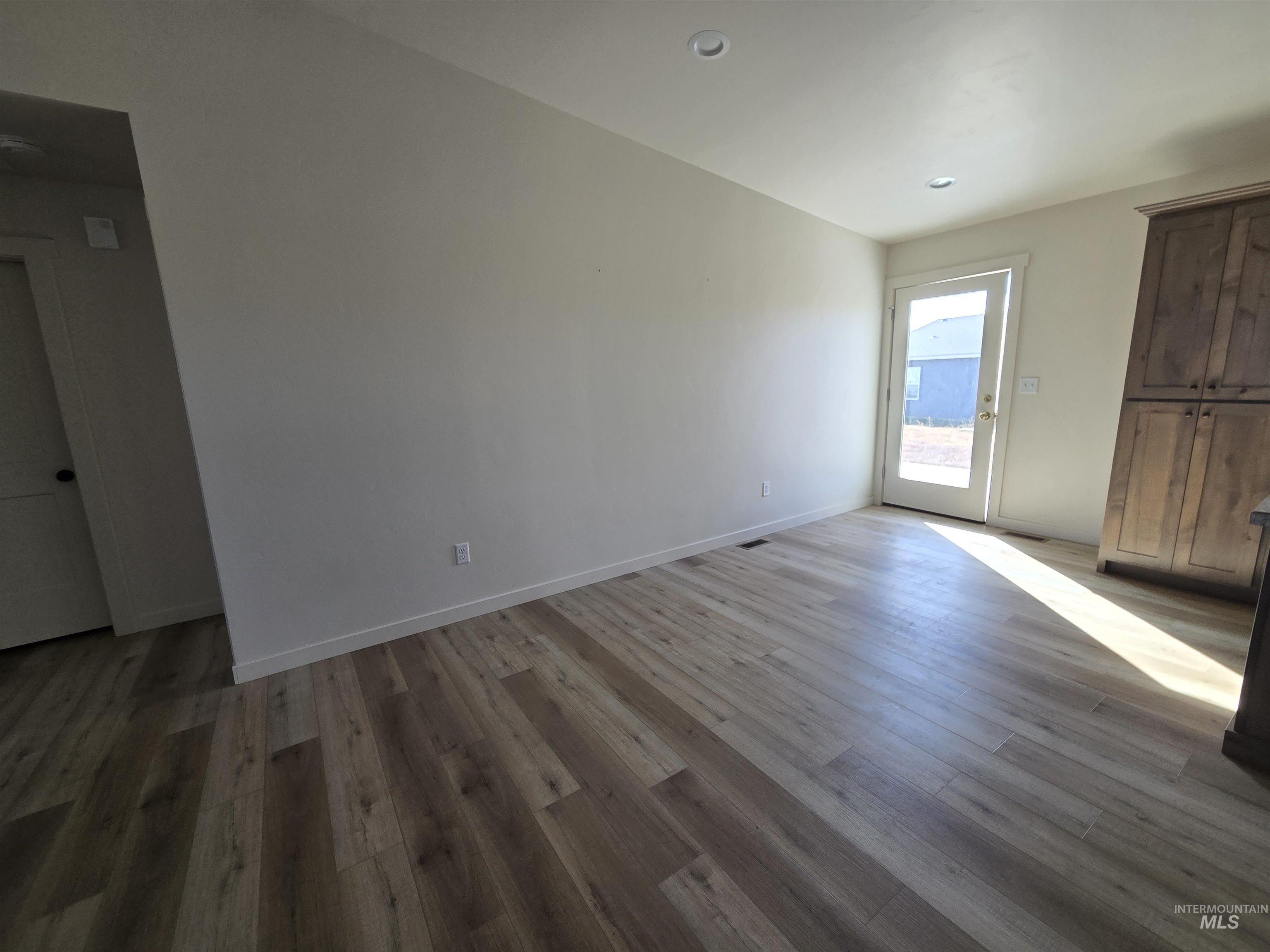 Spare room with light wood finished floors and recessed lighting