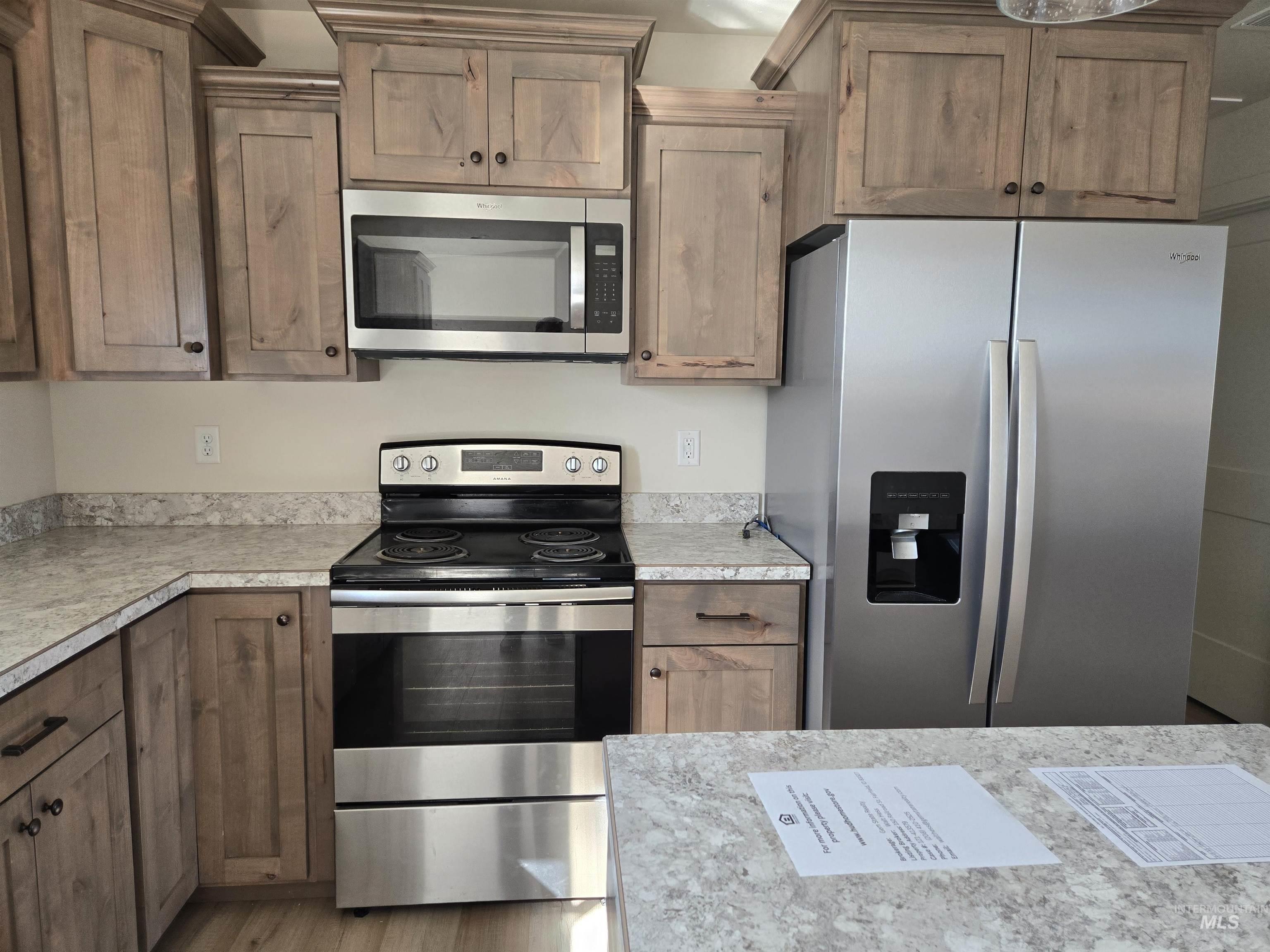 Kitchen featuring appliances with stainless steel finishes, light countertops, and wood finished floors