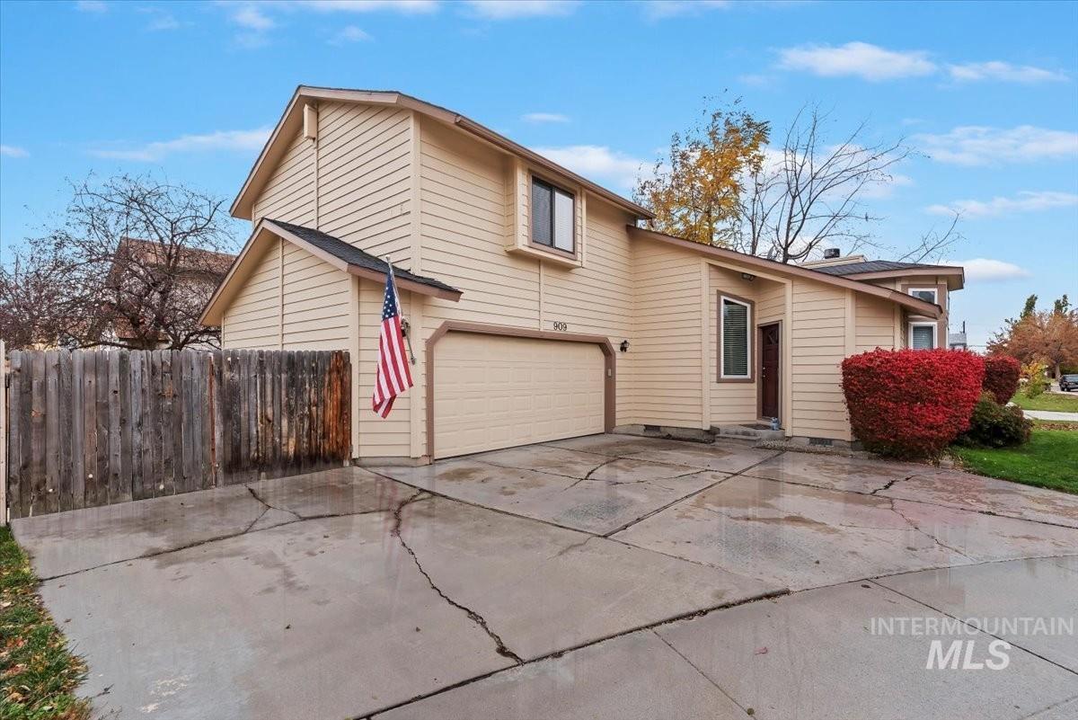 View of front of house featuring an attached garage, concrete driveway, and a patio