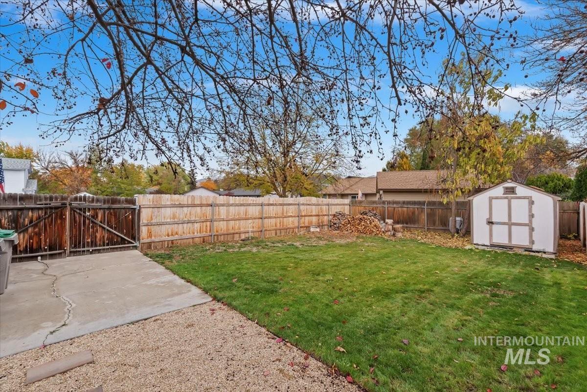 Fenced backyard featuring a storage shed