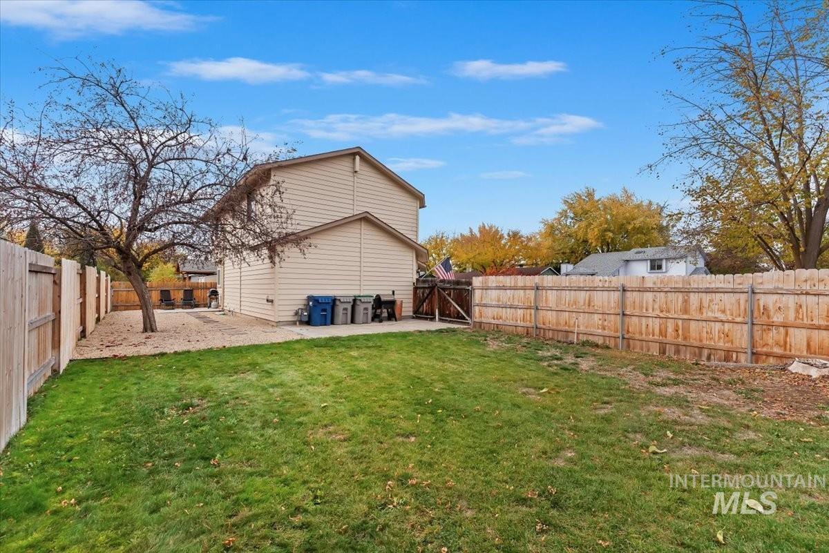 Rear view of house with a fenced backyard and a patio