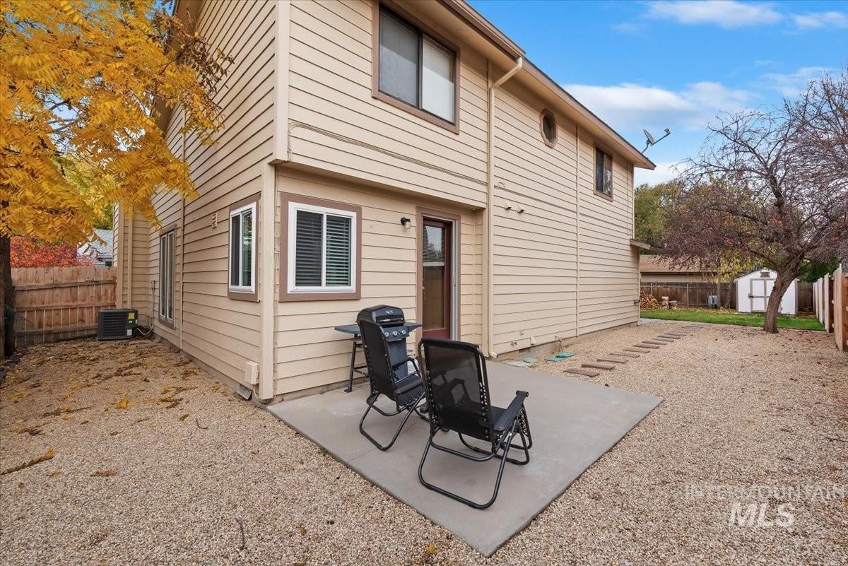 Back of property featuring a patio area, a fenced backyard, and a storage unit