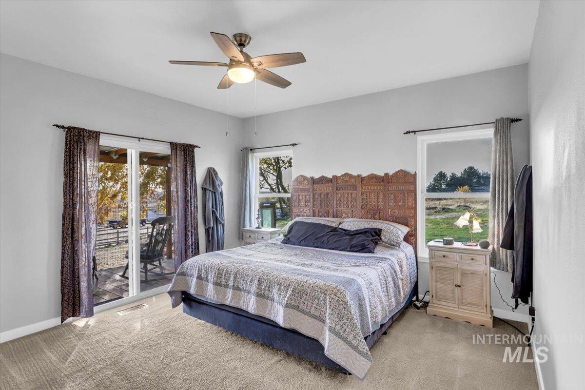 Bedroom featuring light carpet, access to outside, and ceiling fan