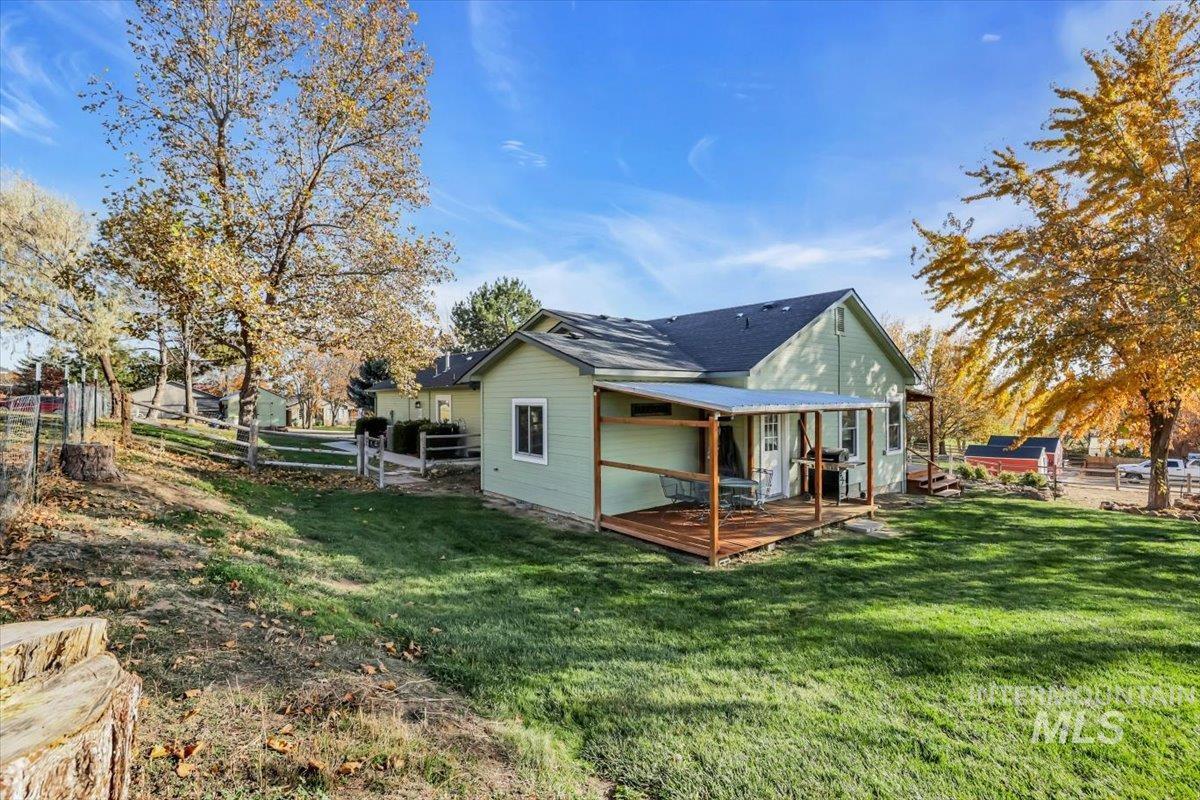 Rear view of house with a fenced backyard and a wooden deck