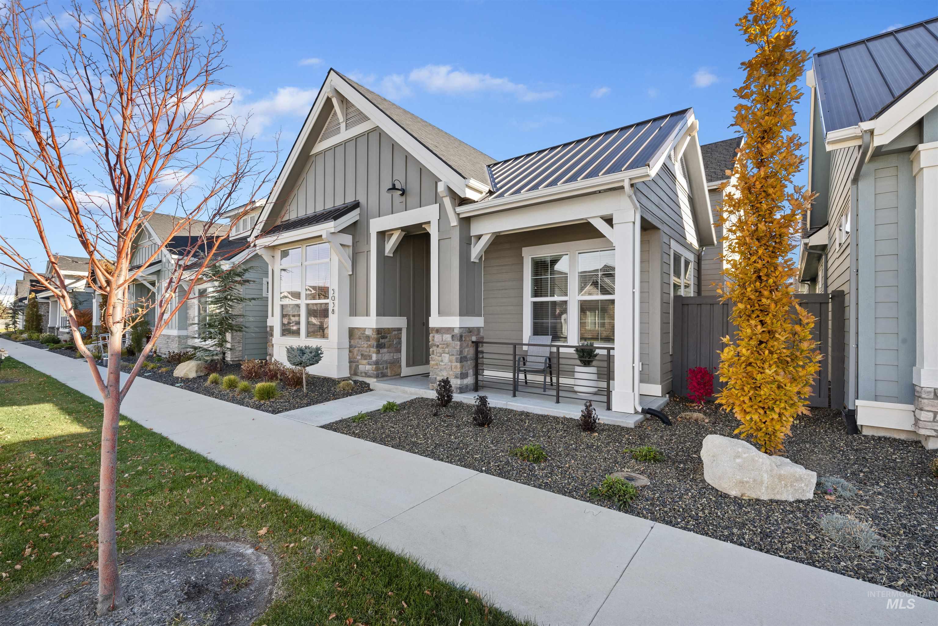 View of front of home featuring a metal roof, board and batten siding, and stone siding