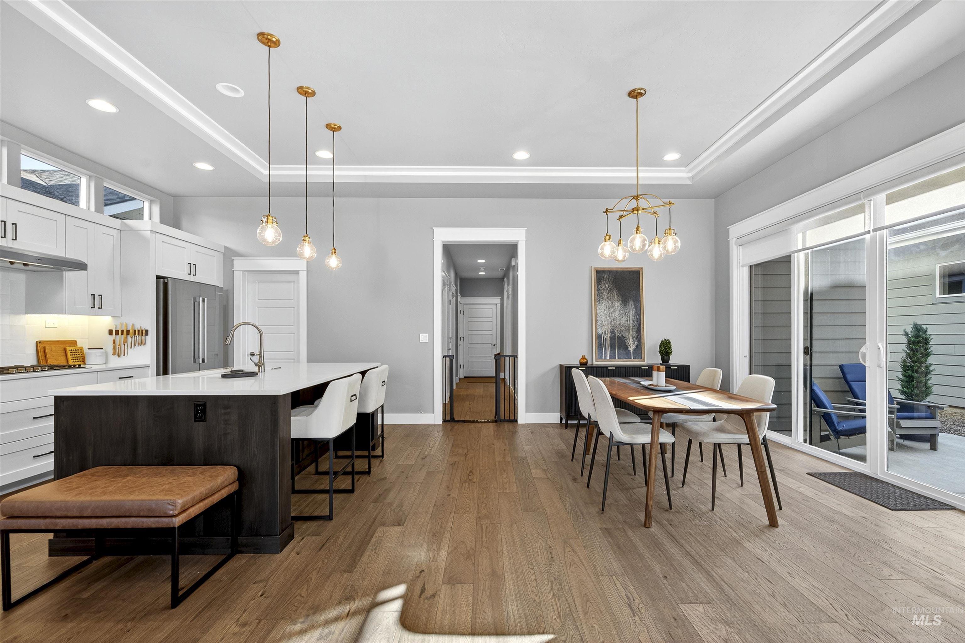 Kitchen featuring white cabinetry, a tray ceiling, a kitchen breakfast bar, dark wood finished floors, and recessed lighting