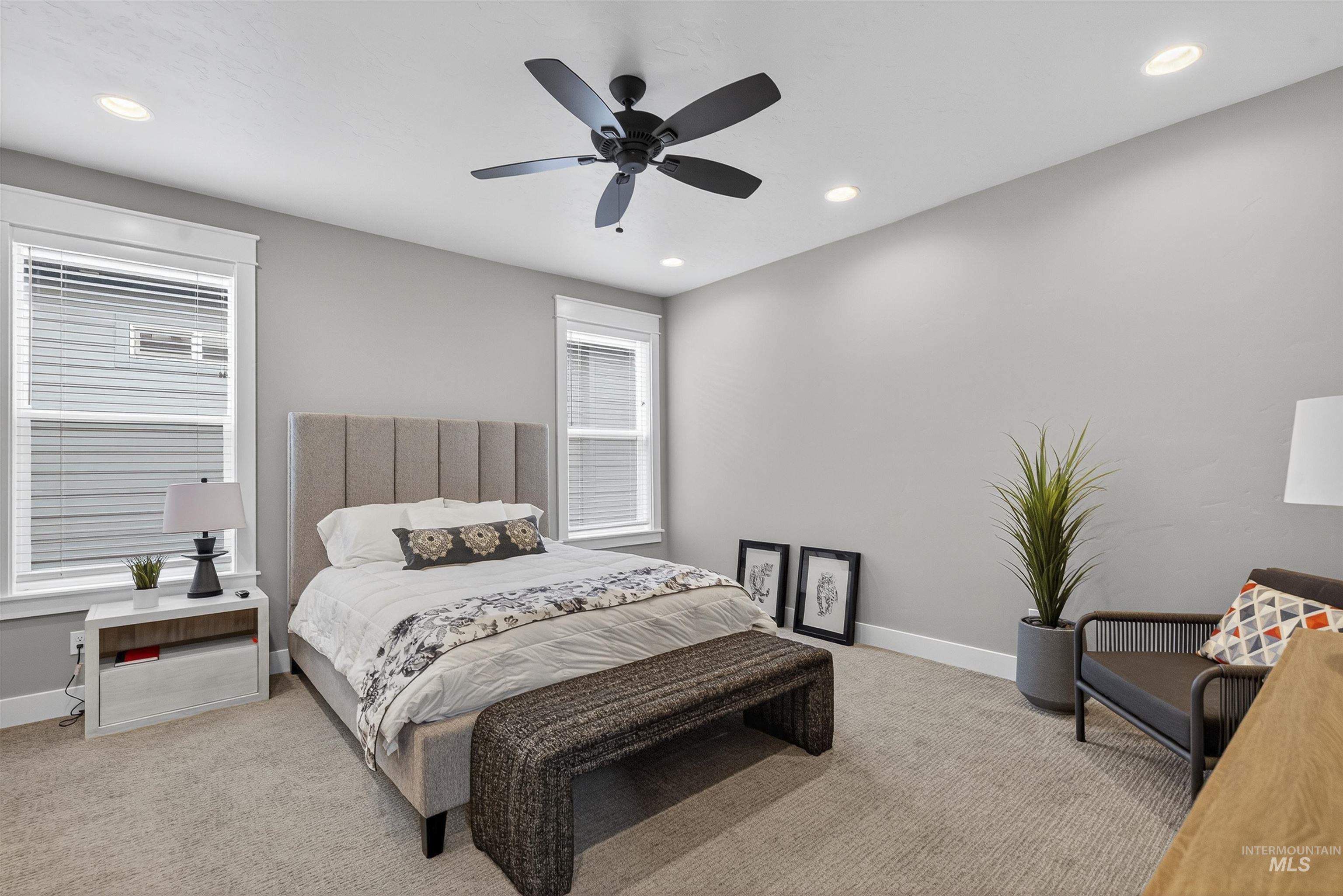 Carpeted bedroom with recessed lighting and a ceiling fan