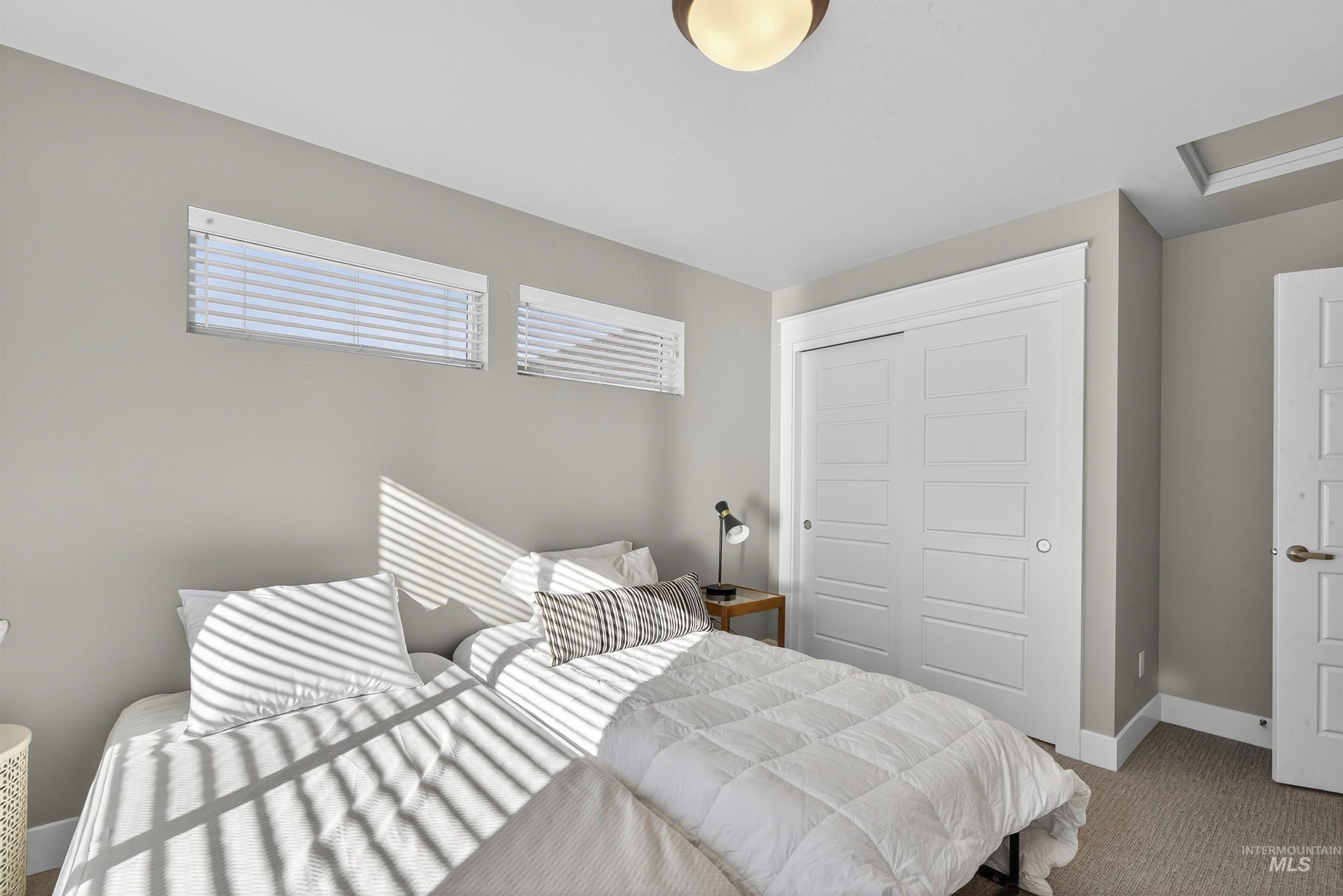 Carpeted bedroom with a closet and attic access