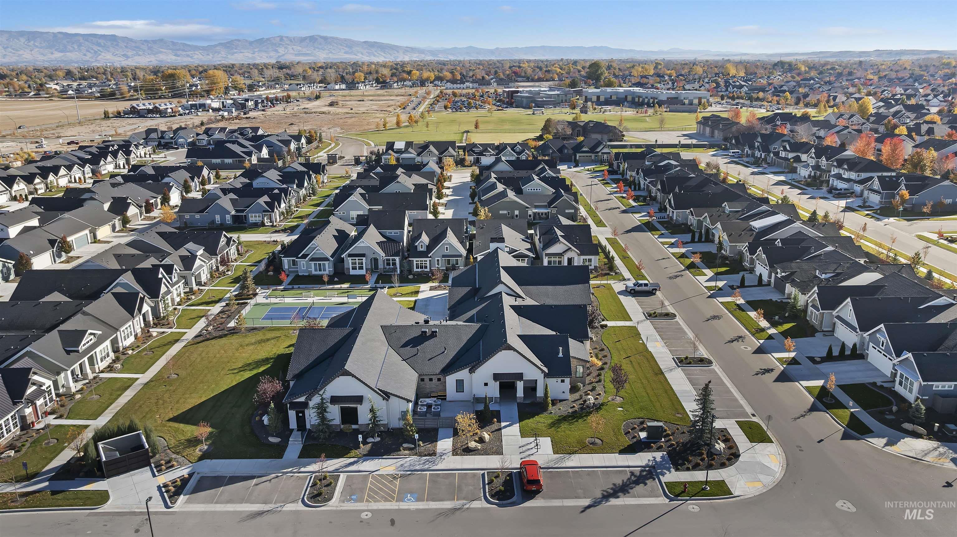 Aerial view of property and surrounding area featuring mountains and nearby suburban area