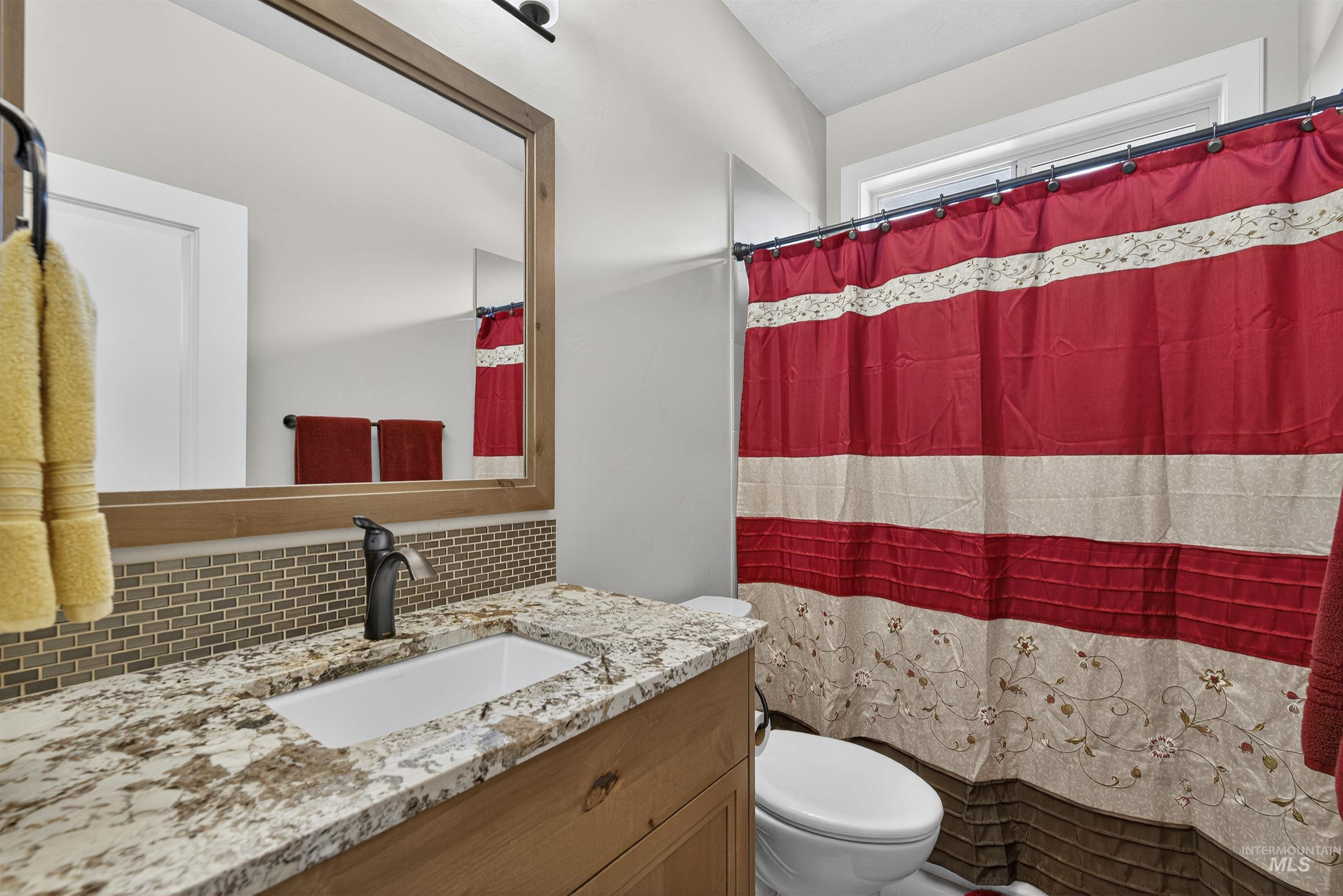 Bathroom featuring tasteful backsplash and vanity