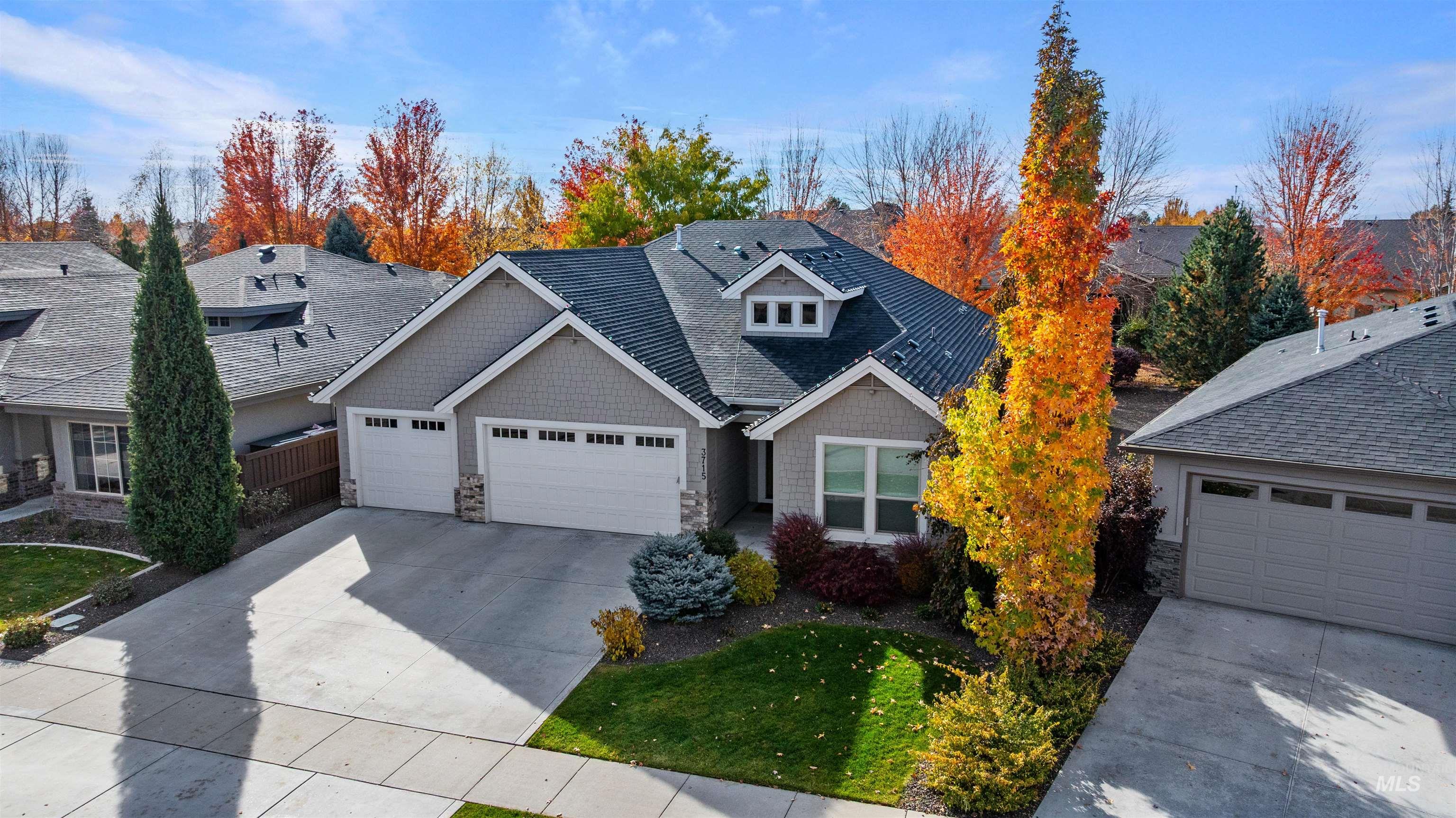 View of front of house with stone siding, an attached garage, and concrete driveway