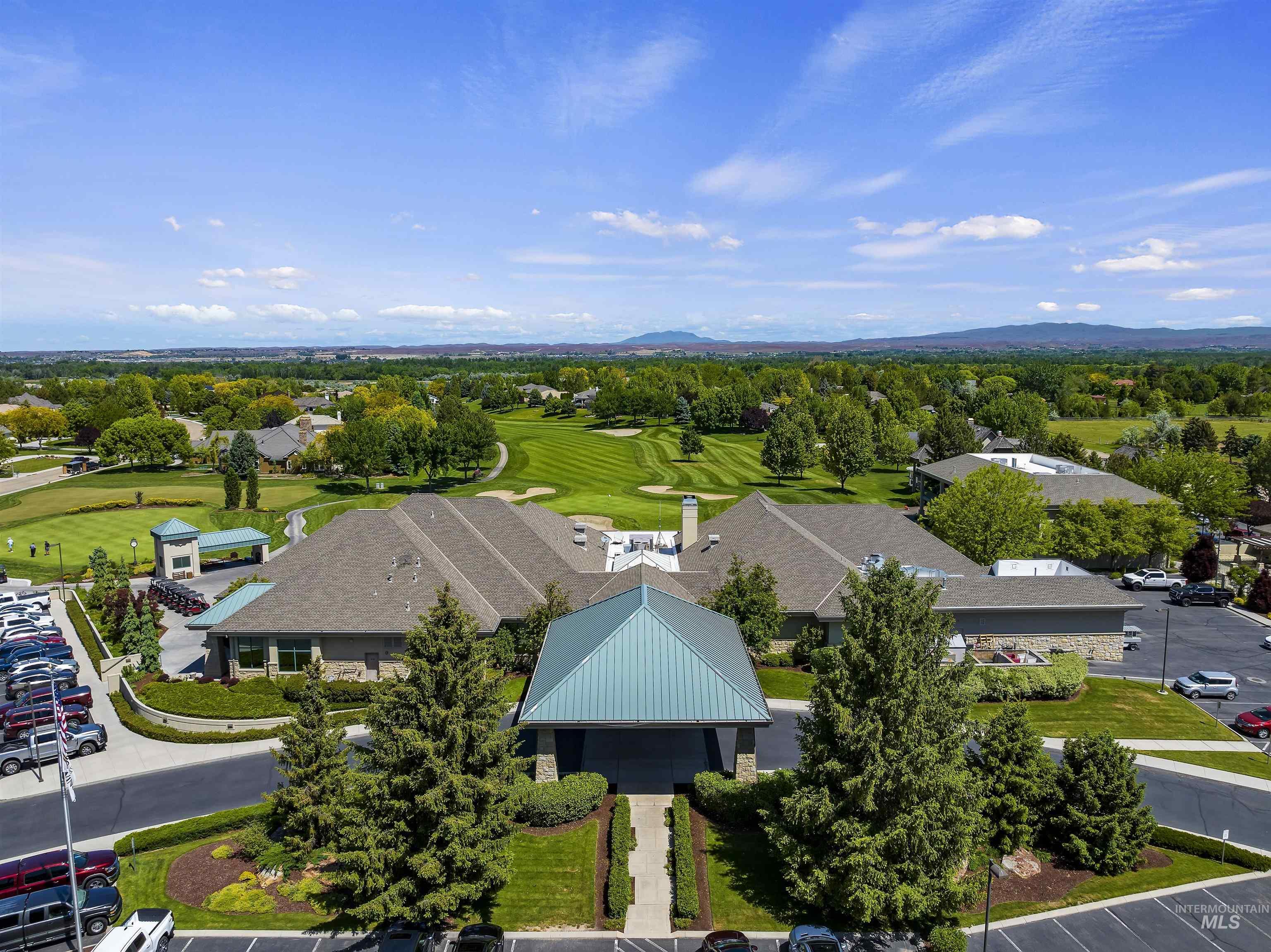 Aerial perspective of suburban area with a mountain backdrop and a local golf course