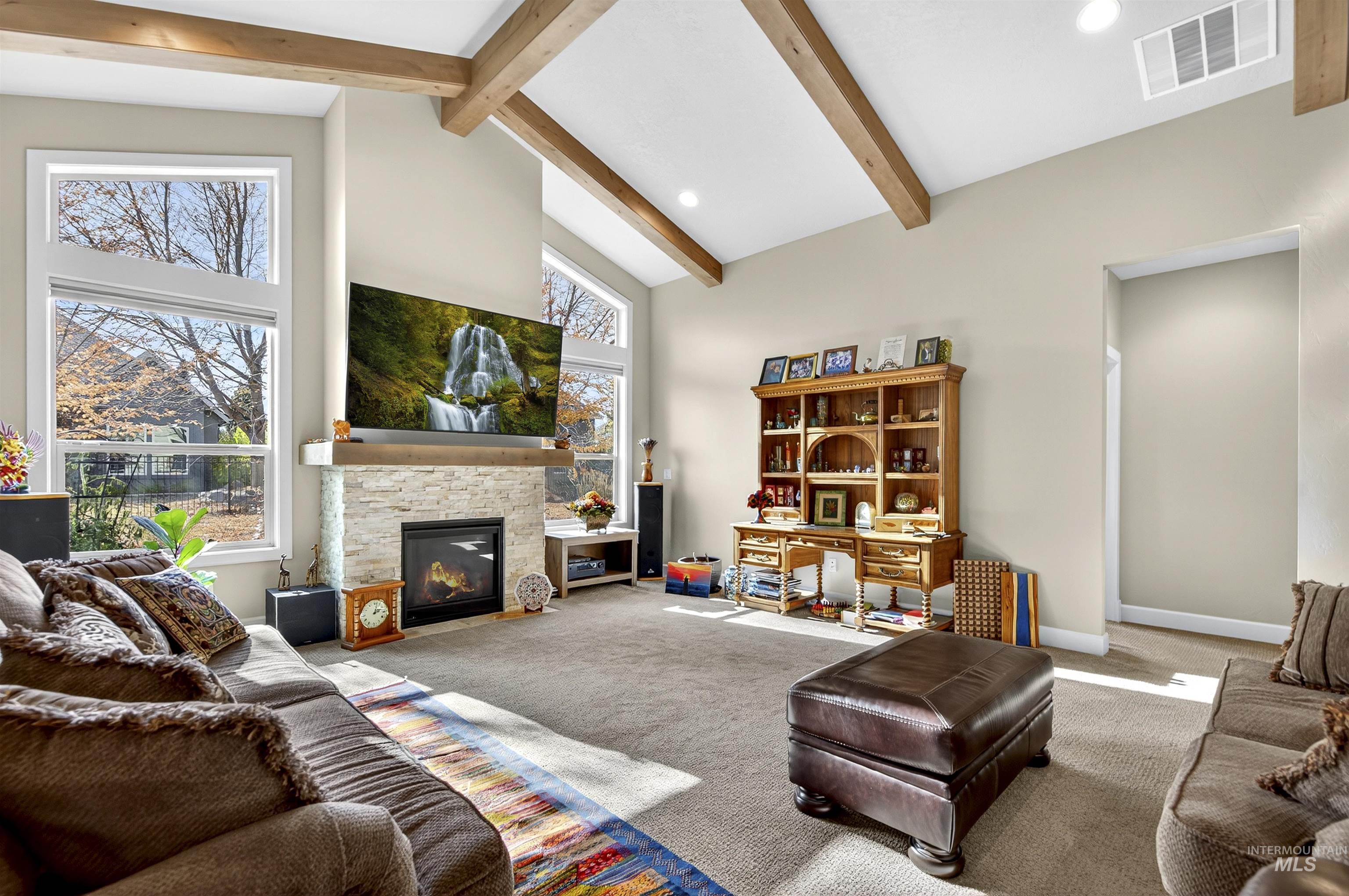 Living area with high vaulted ceiling, carpet, a fireplace, beam ceiling, and recessed lighting
