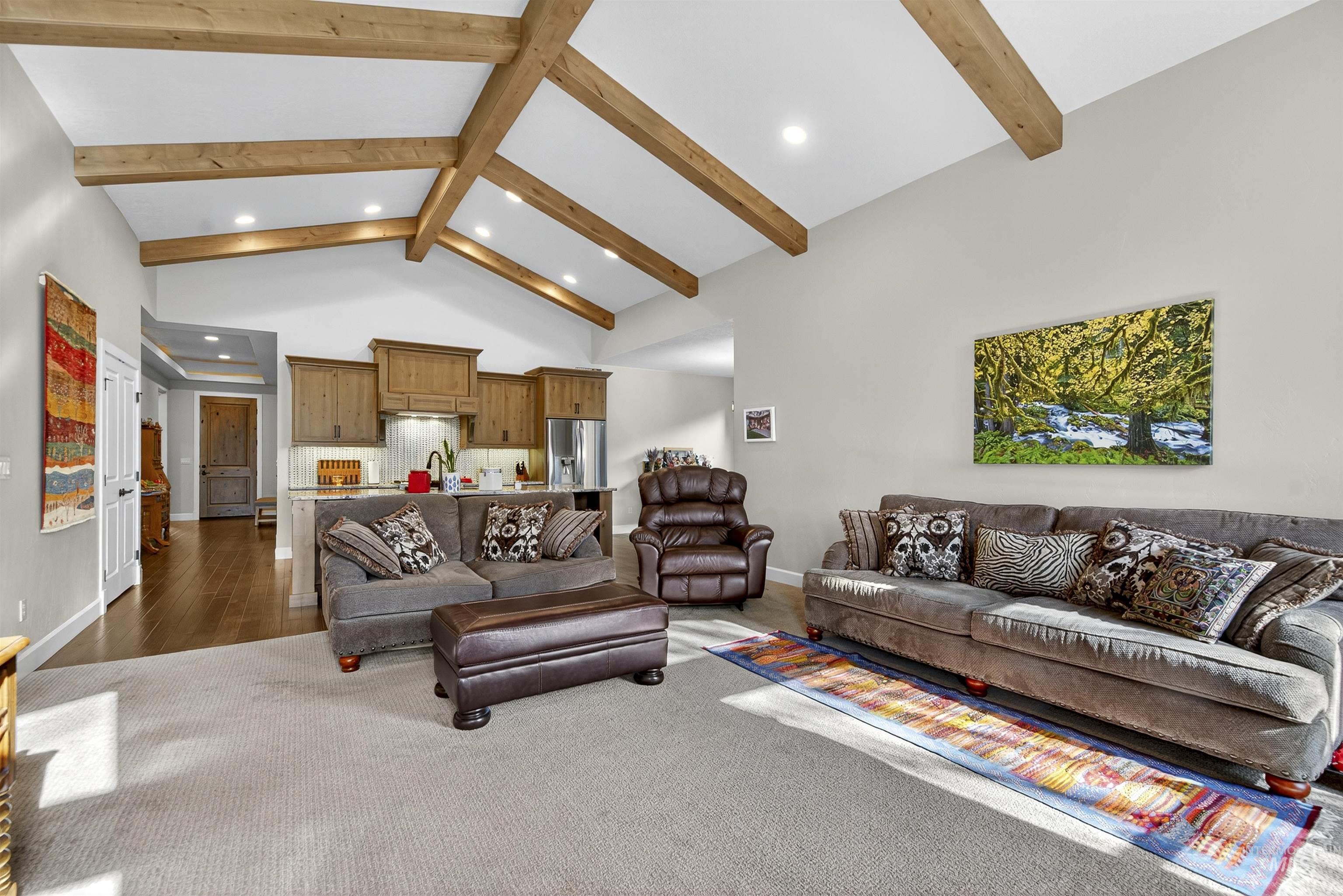 Living area featuring beam ceiling, high vaulted ceiling, wood finished floors, and recessed lighting