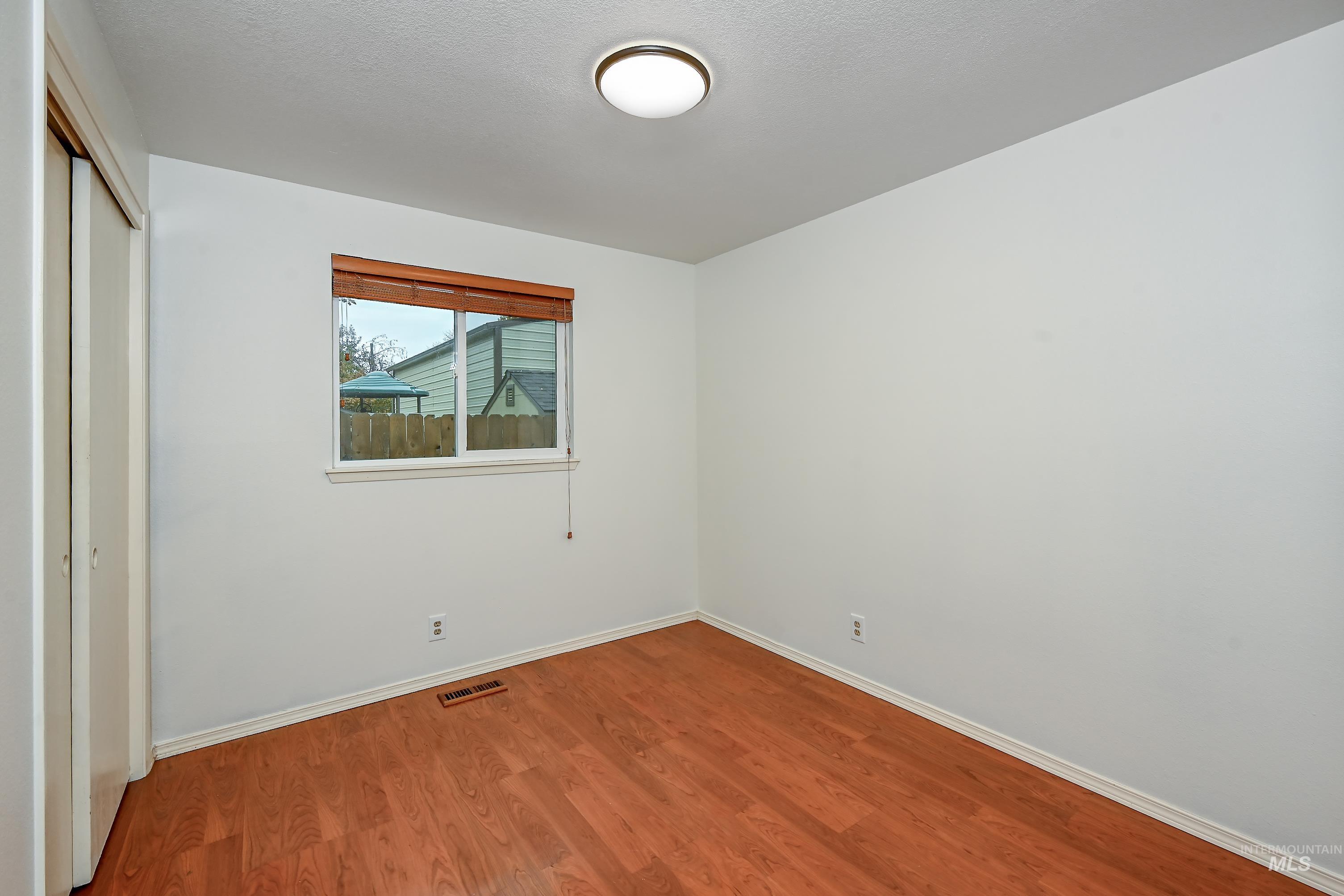 Unfurnished bedroom featuring wood finished floors and a closet