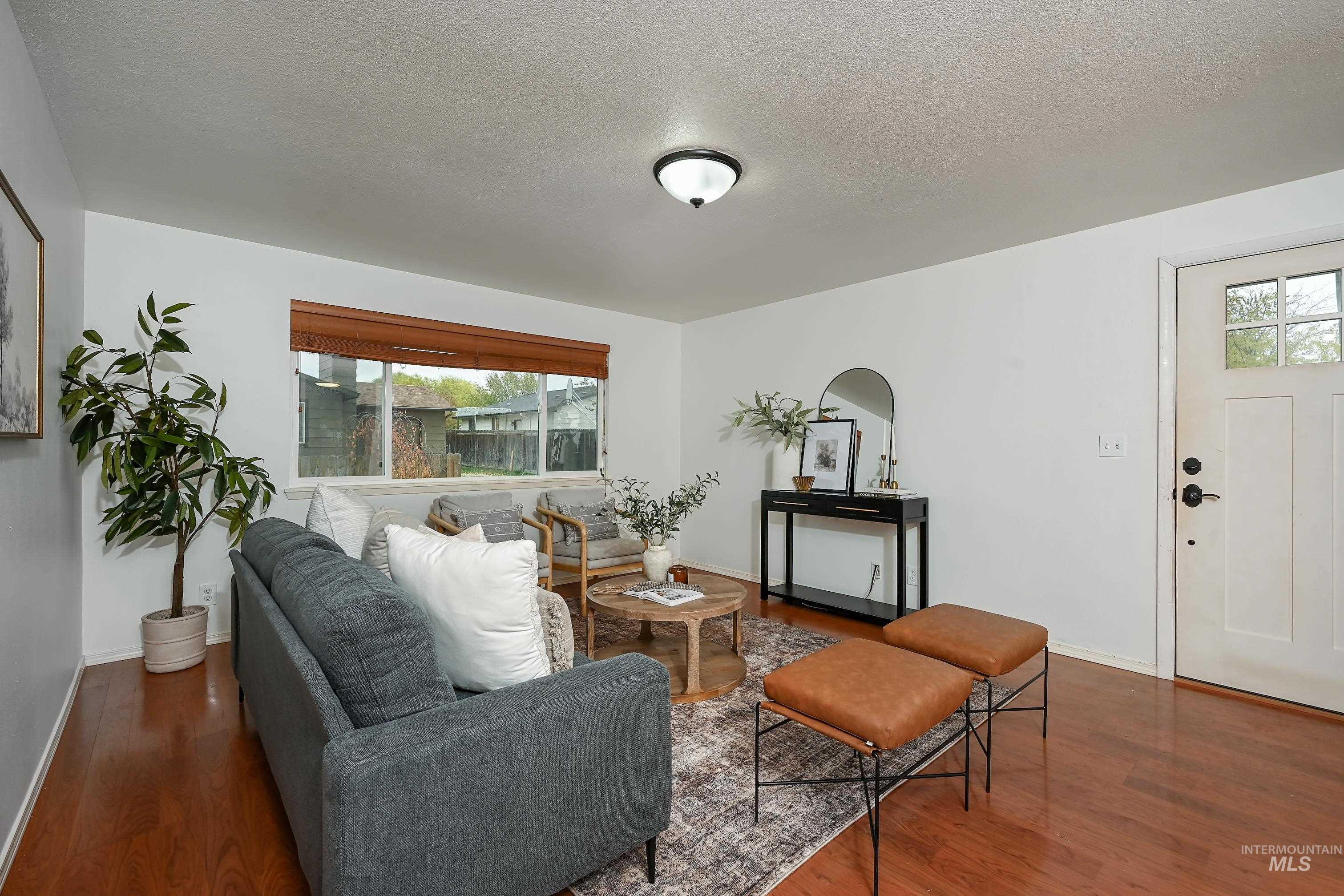 Living area with dark wood-style flooring and a textured ceiling