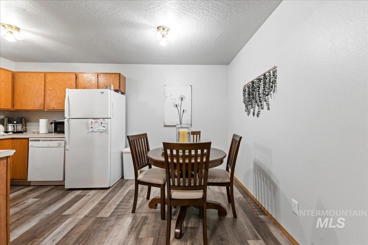 Dining room with light wood-style flooring and a textured ceiling