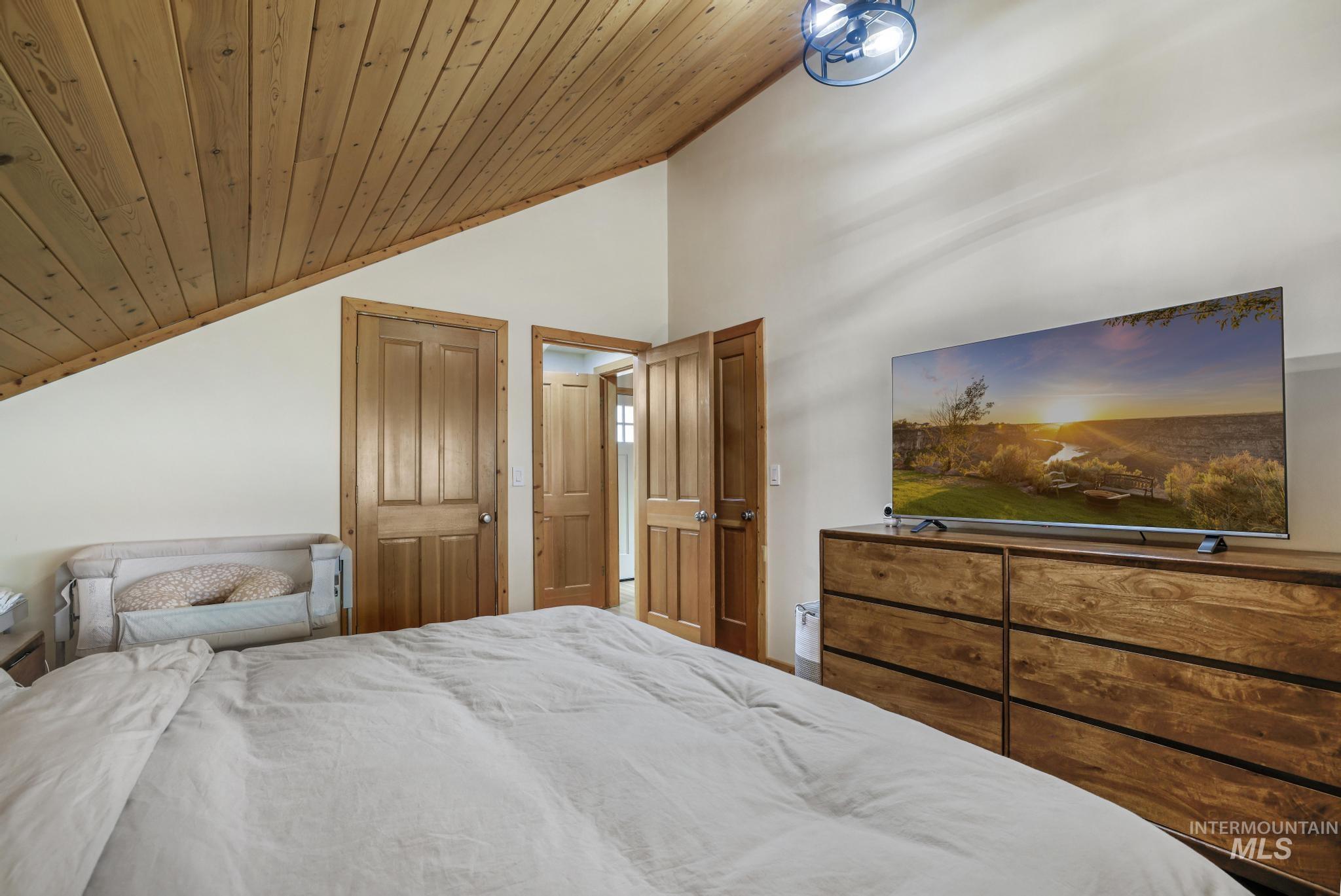 Bedroom featuring vaulted ceiling, a closet, and wooden ceiling