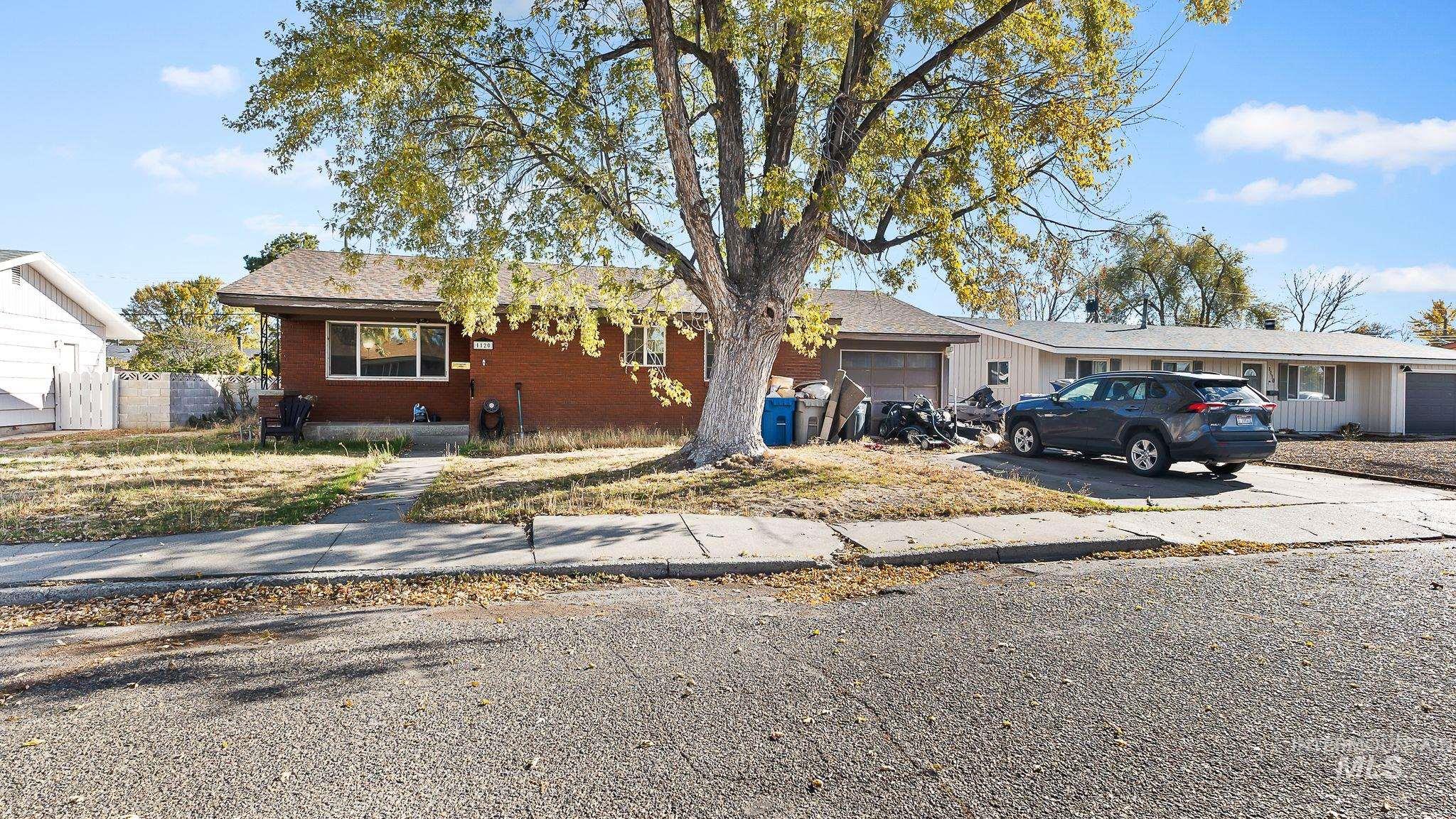 Ranch-style home featuring driveway, brick siding, and an attached garage