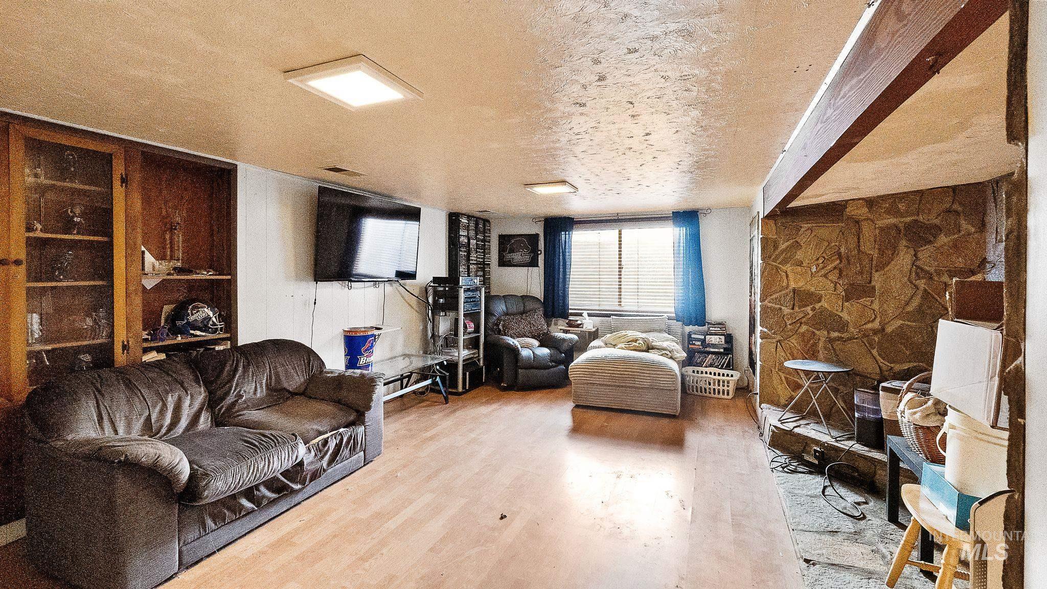 Living room with a textured ceiling and wood finished floors