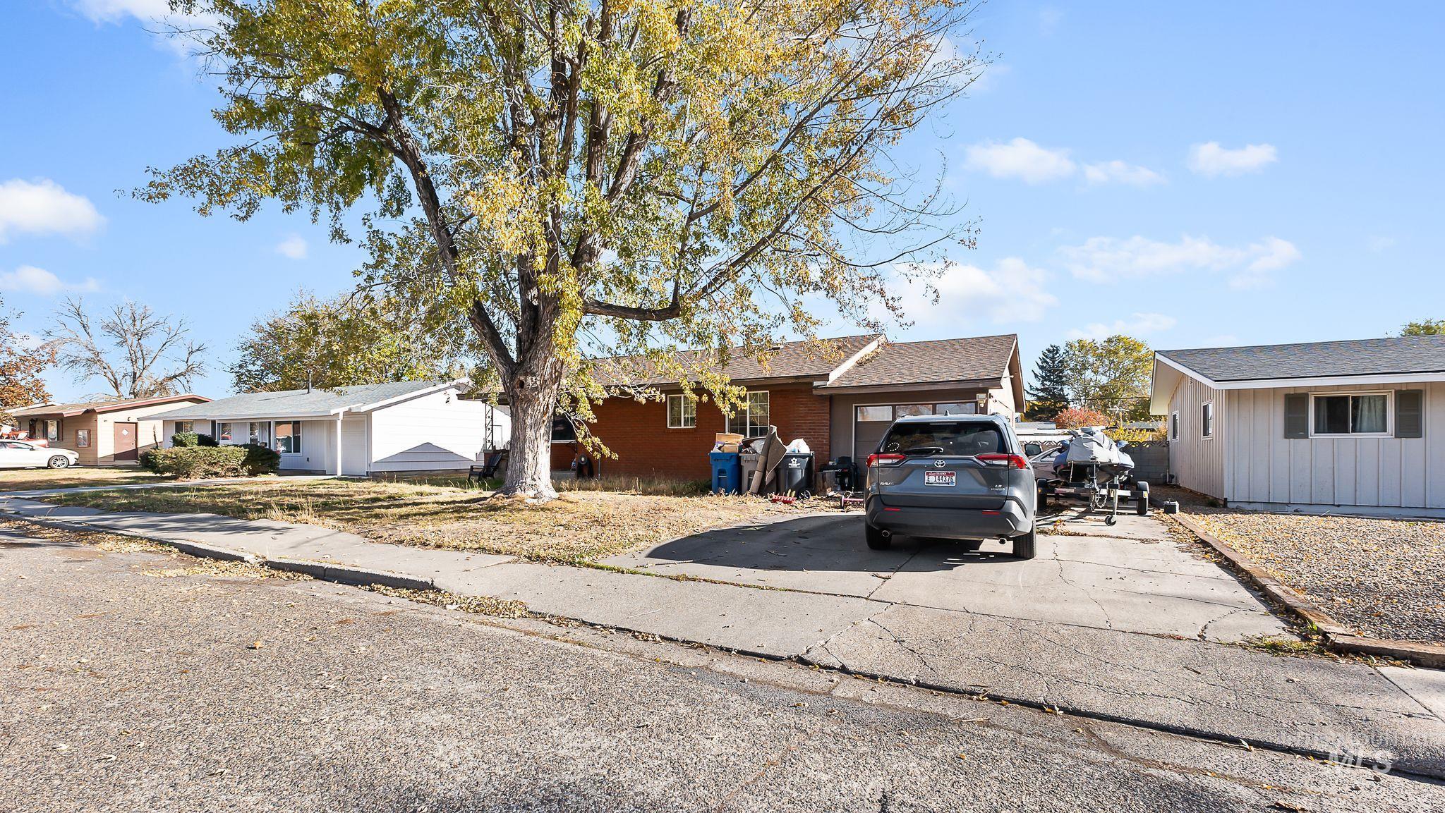 Ranch-style house with brick siding, driveway, a shingled roof, and an attached garage