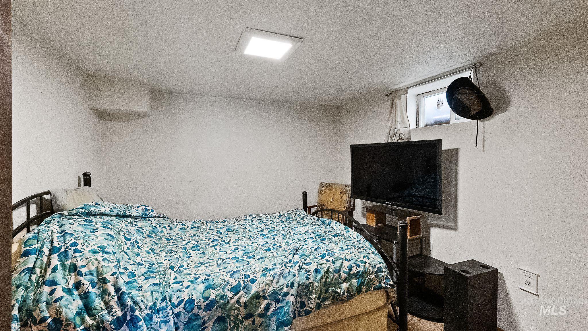 Bedroom featuring a textured ceiling and a textured wall