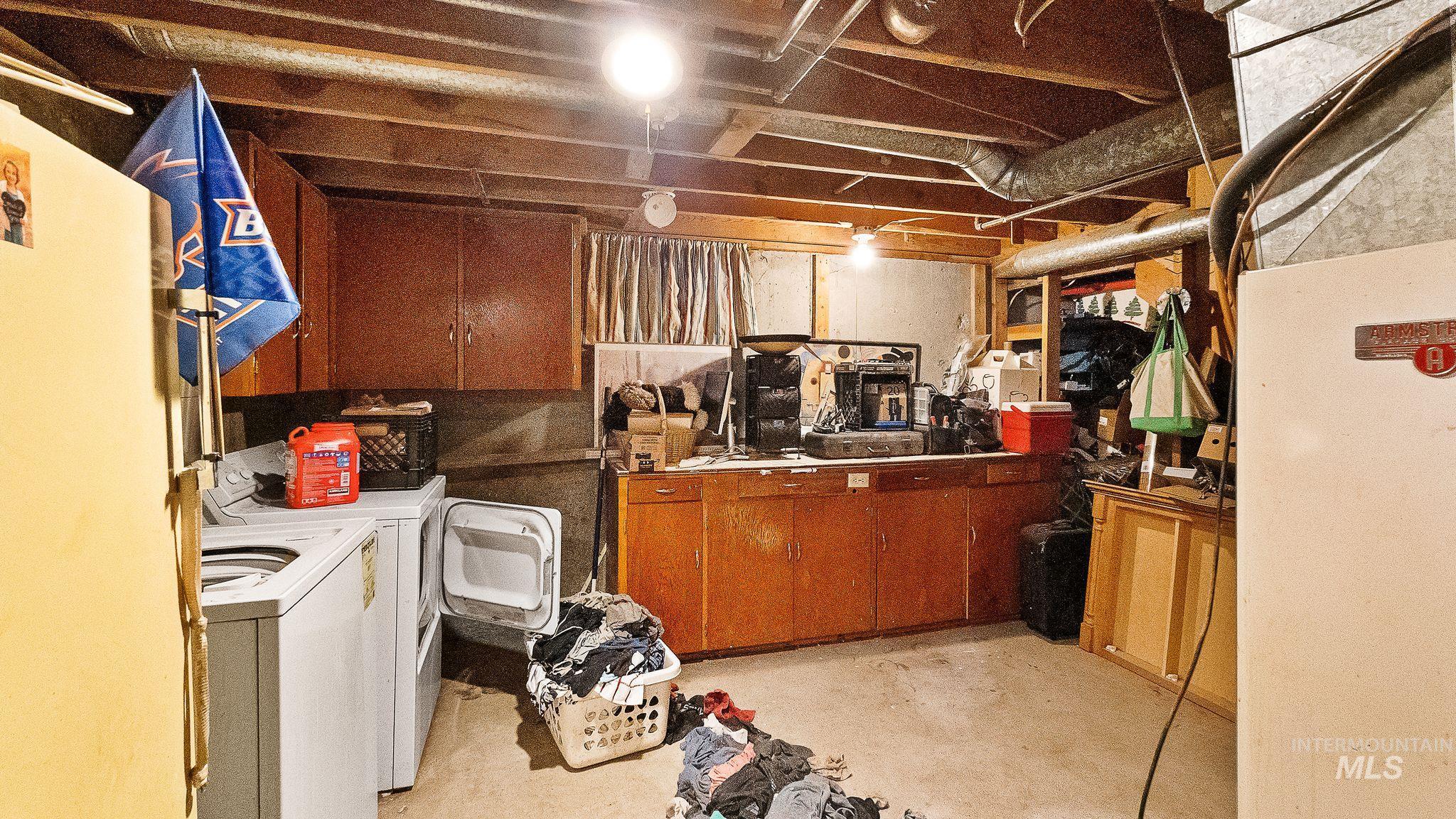 Unfinished below grade area with heating unit and independent washer and dryer