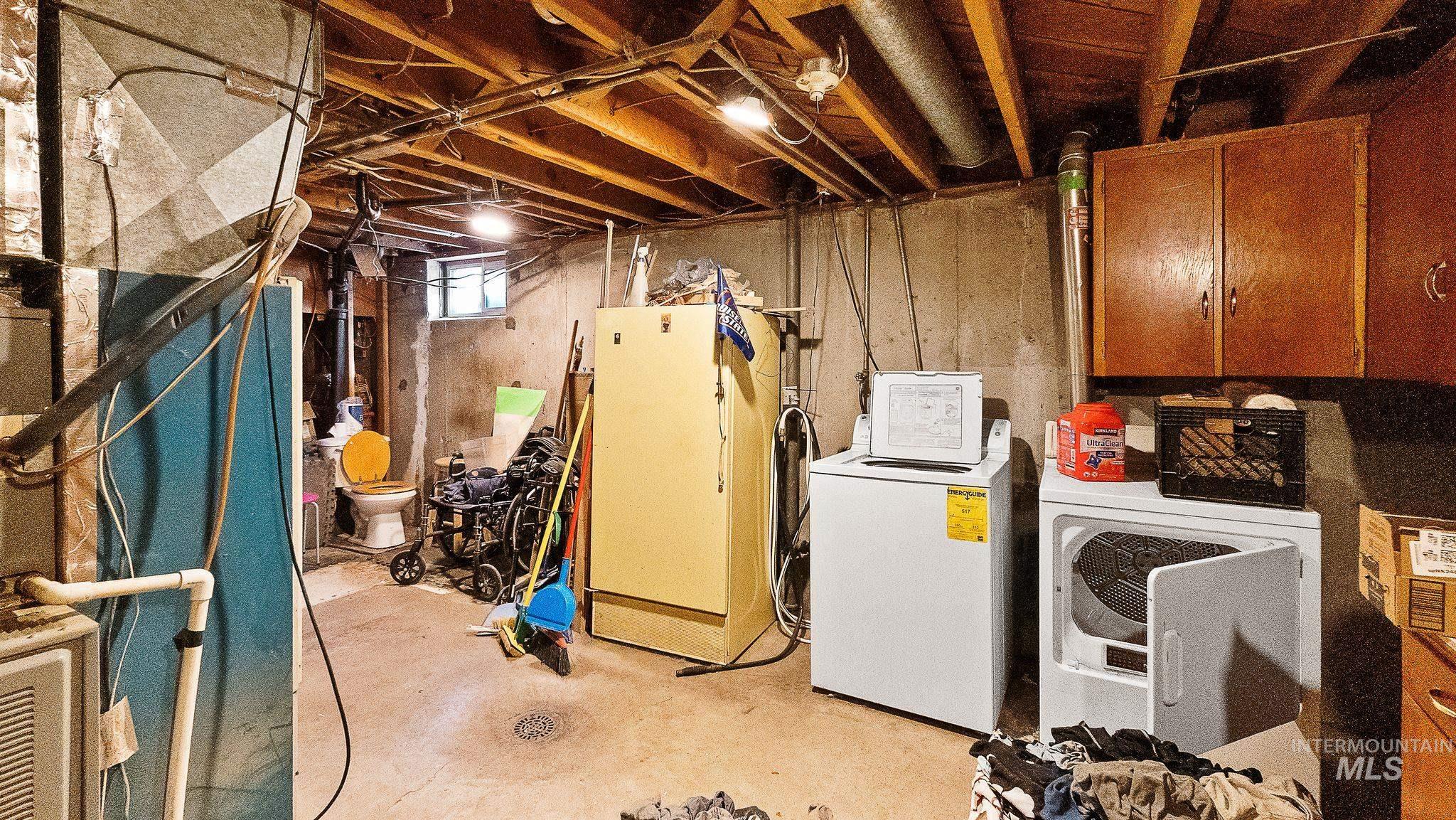 Below grade area featuring washing machine and clothes dryer and heating unit