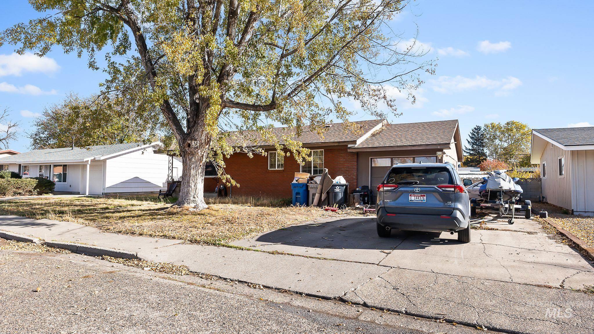 Ranch-style home featuring brick siding, a shingled roof, driveway, and a garage