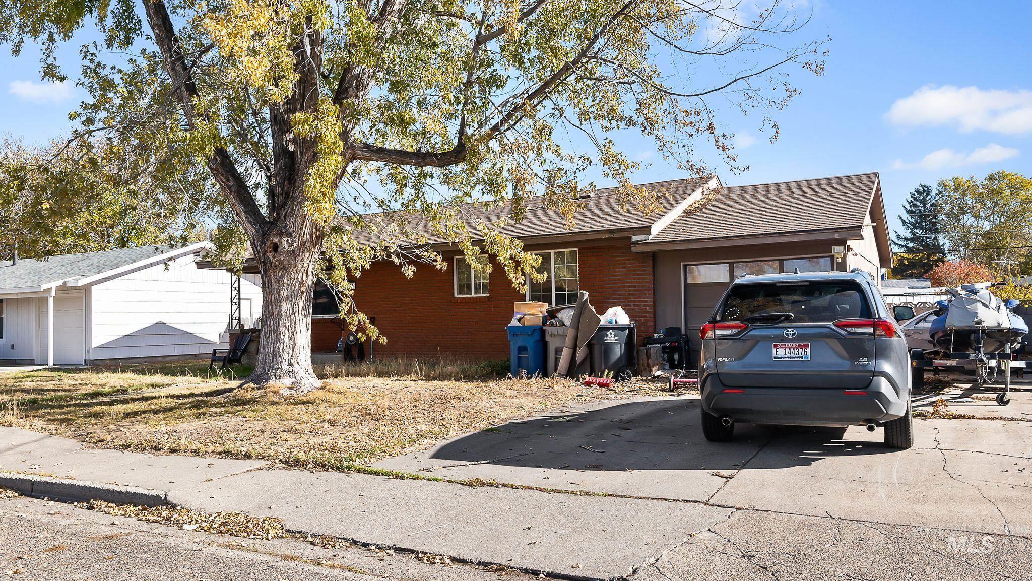Ranch-style home featuring brick siding, a shingled roof, and an attached garage
