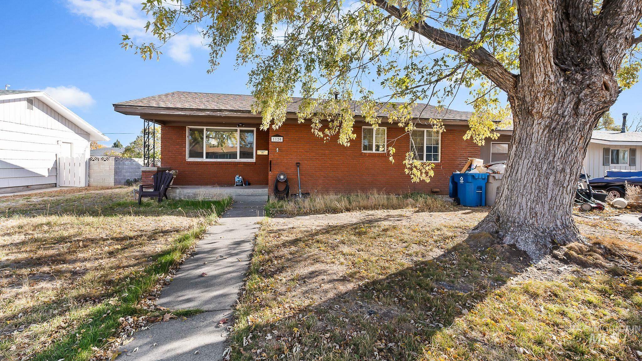 View of front of home featuring brick siding and roof with shingles