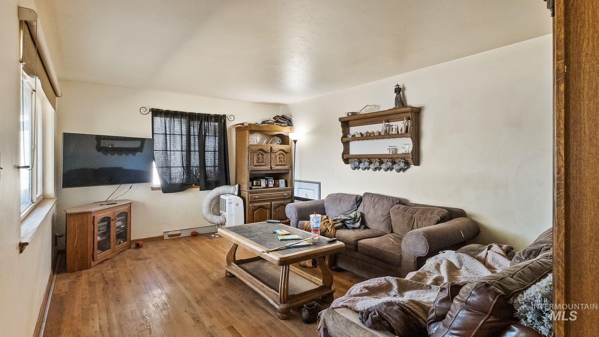 Living room featuring wood finished floors and a baseboard radiator
