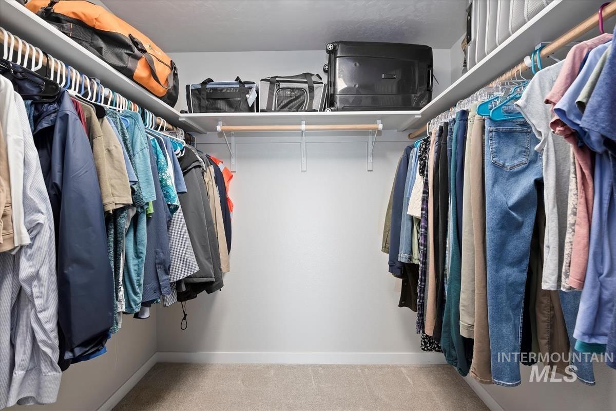 Spacious closet with light carpet