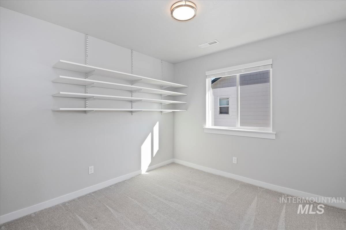 Spare room with baseboards and light colored carpet