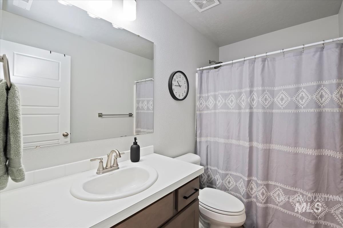 Bathroom featuring curtained shower and vanity