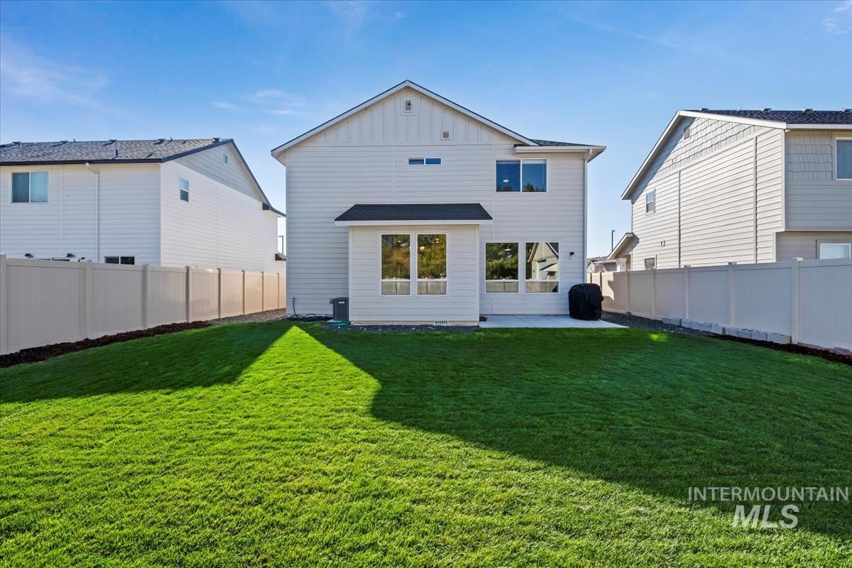 Back of house featuring a patio area, board and batten siding, and a fenced backyard