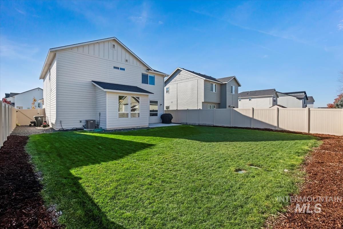 Back of property featuring a fenced backyard and board and batten siding