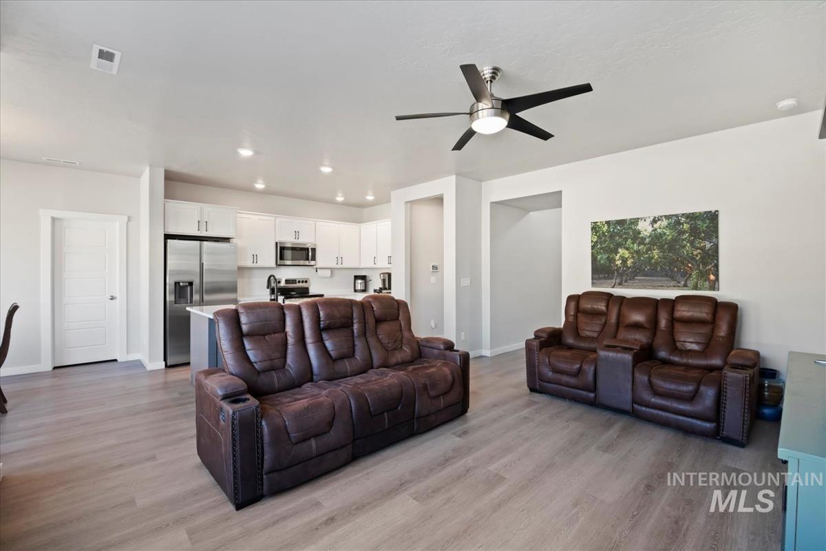 Living area featuring light wood-style flooring, recessed lighting, and a ceiling fan