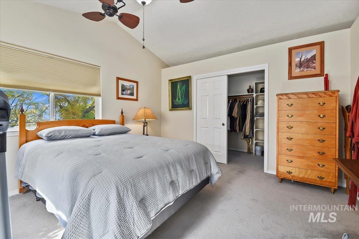 Bedroom featuring lofted ceiling, light carpet, and ceiling fan