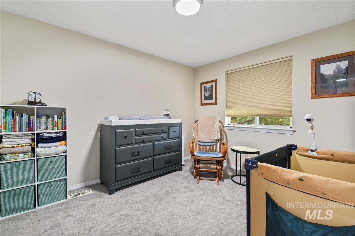 Bedroom featuring light carpet and baseboards