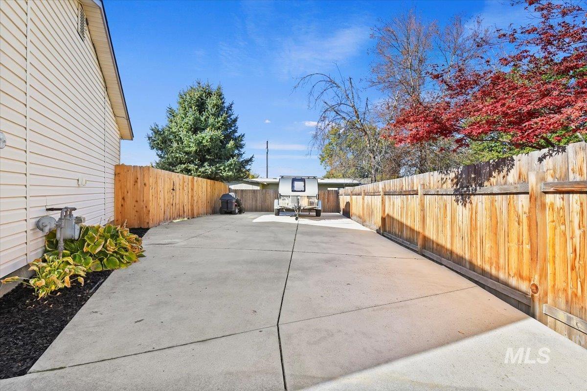 Fenced backyard with a patio and a grill