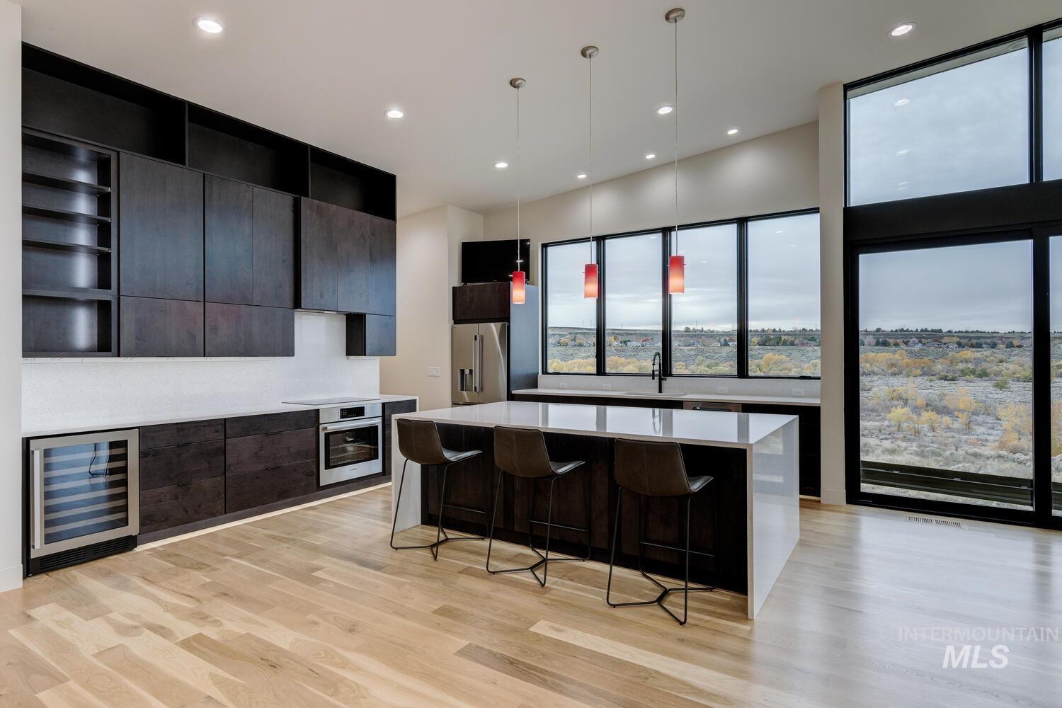 Kitchen with open shelves, pendant lighting, modern cabinets, beverage cooler, and a kitchen island