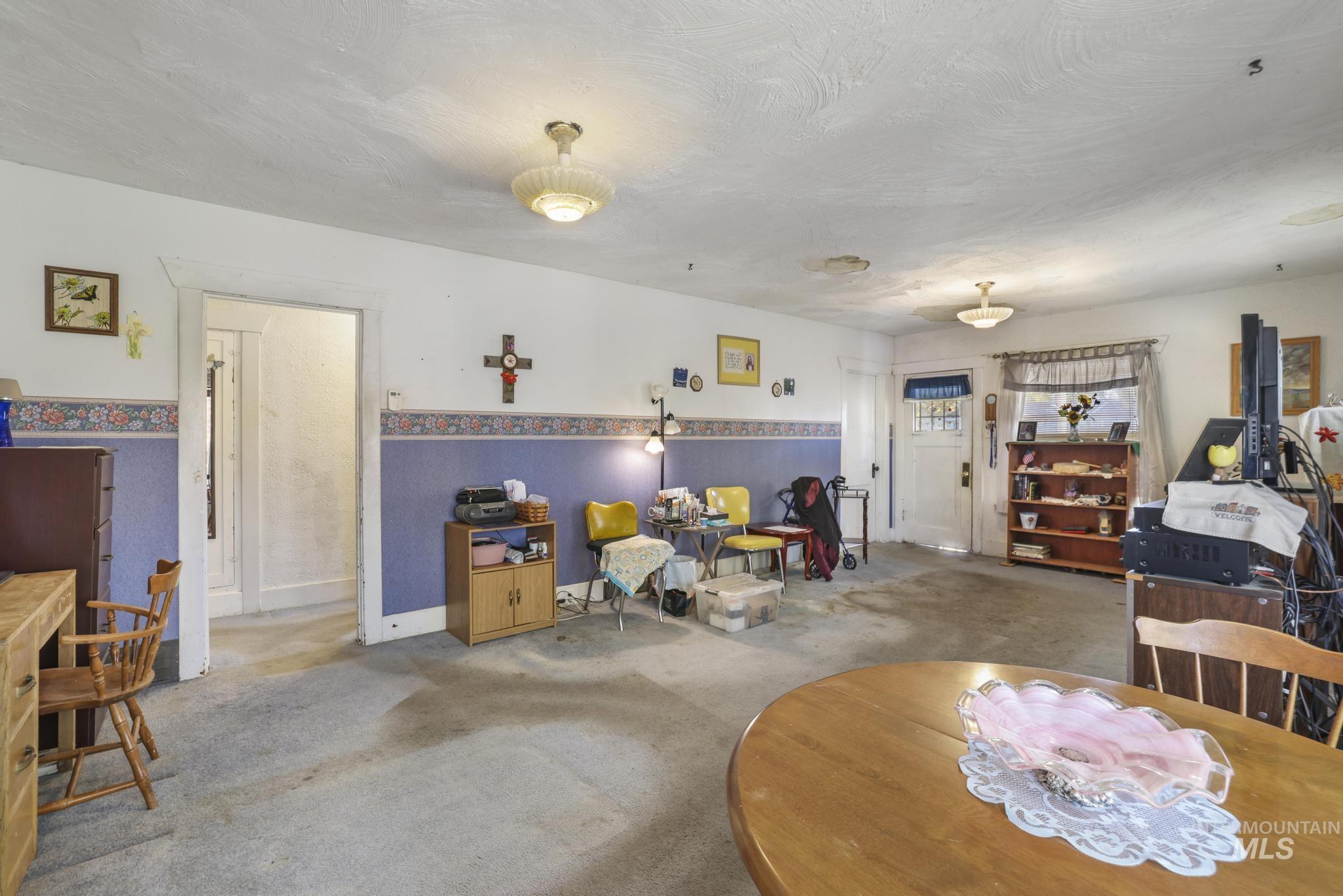 Carpeted dining area with a textured ceiling and baseboards