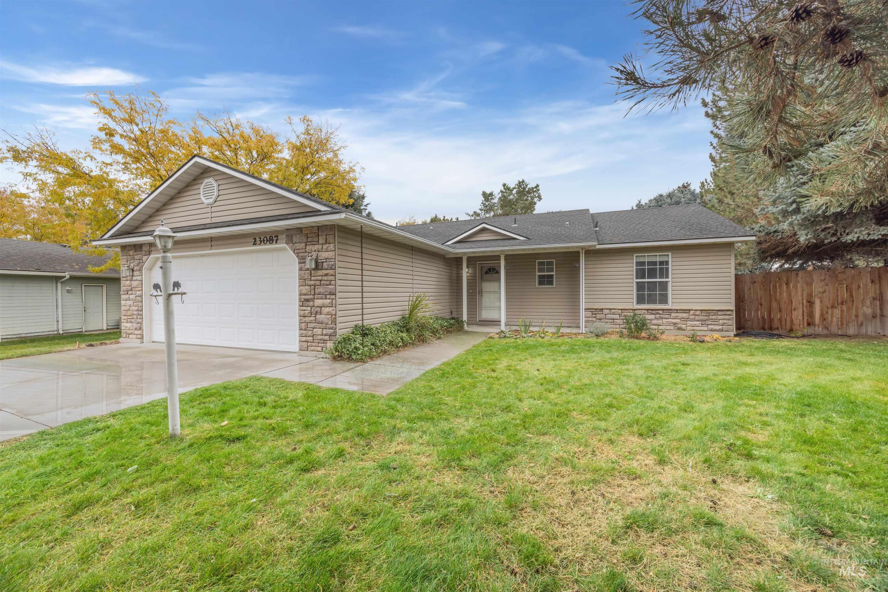 Single story home featuring stone siding, concrete driveway, and an attached garage