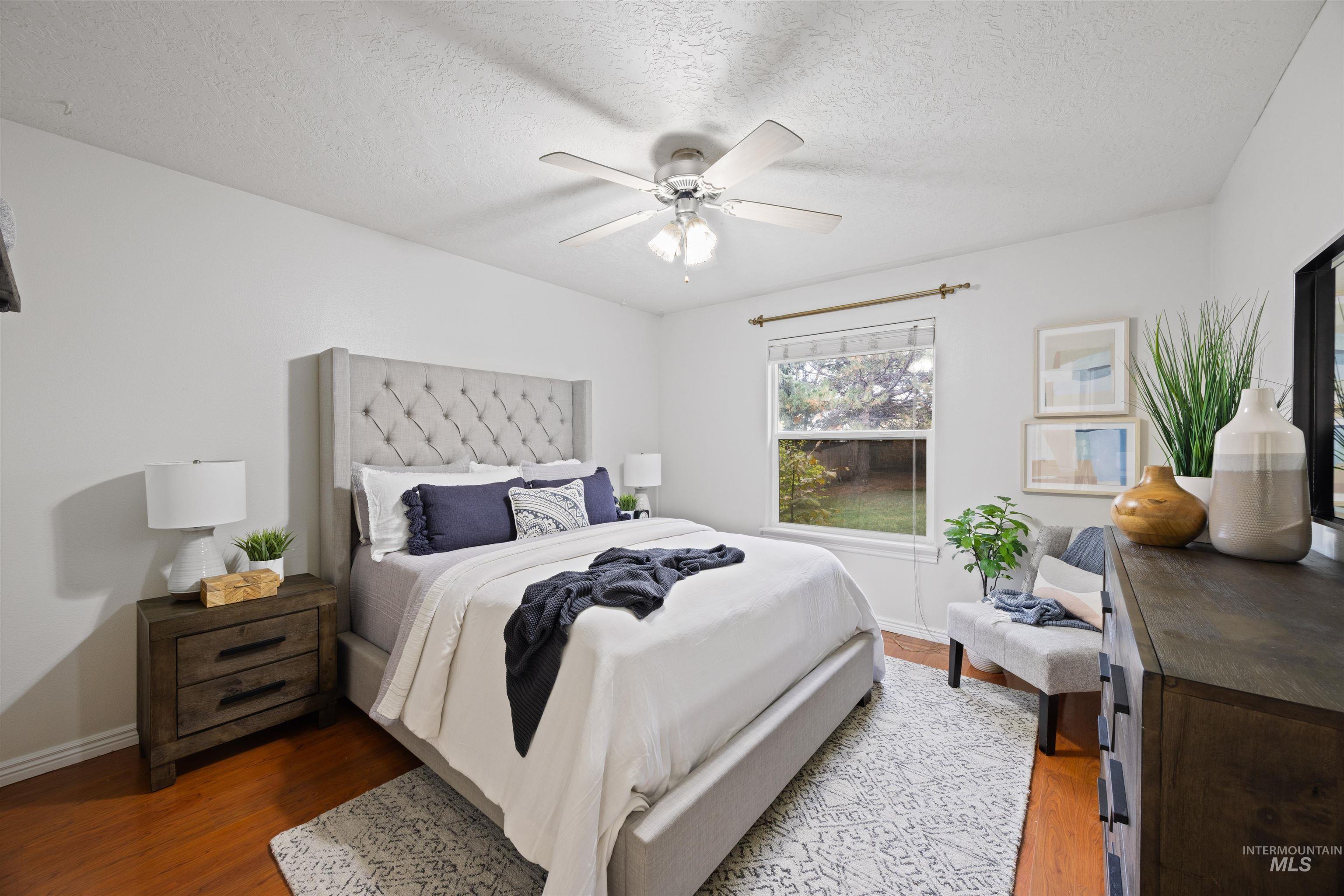 Bedroom featuring wood finished floors, ceiling fan, and a textured ceiling
