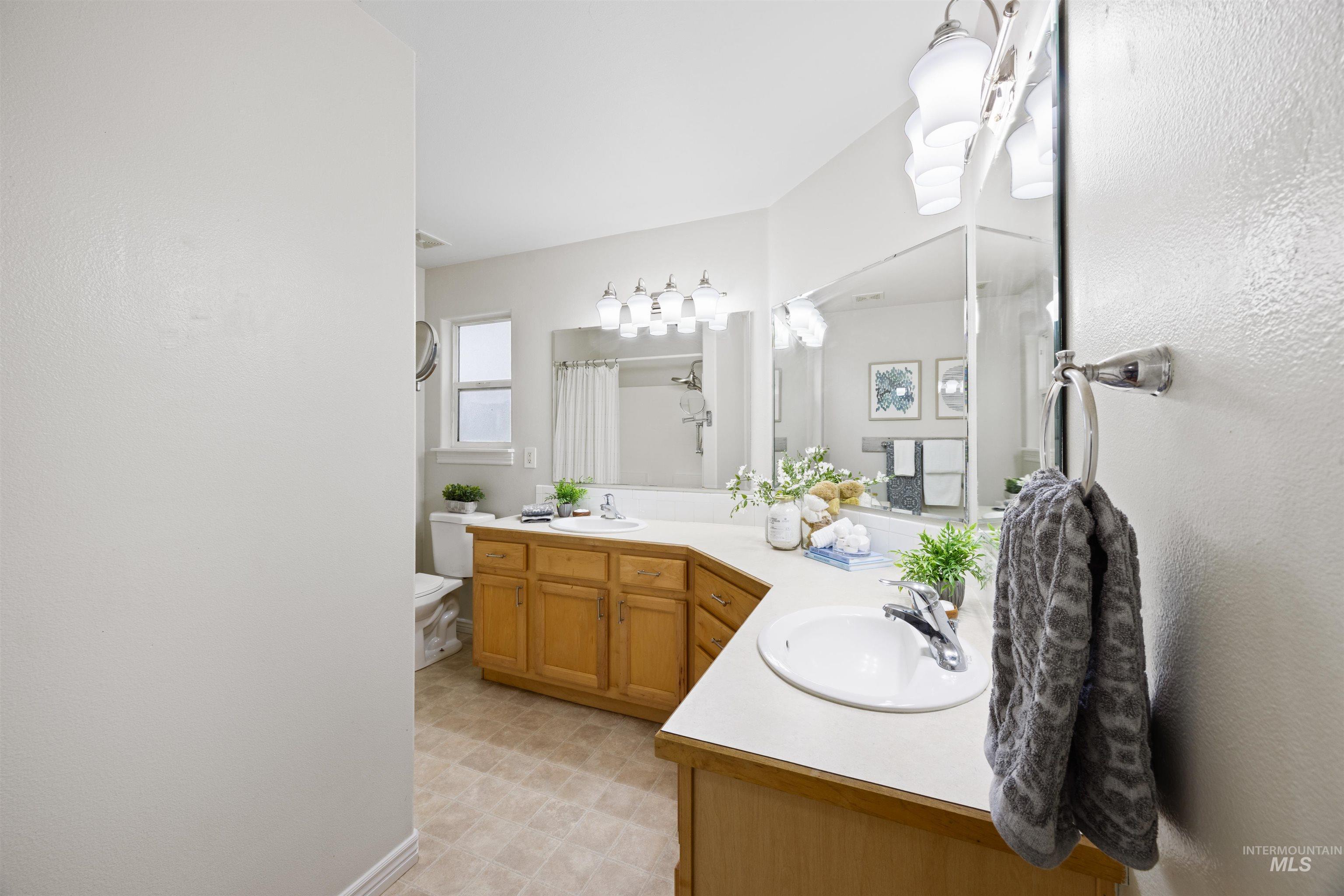 Full bathroom featuring double vanity and a shower with shower curtain