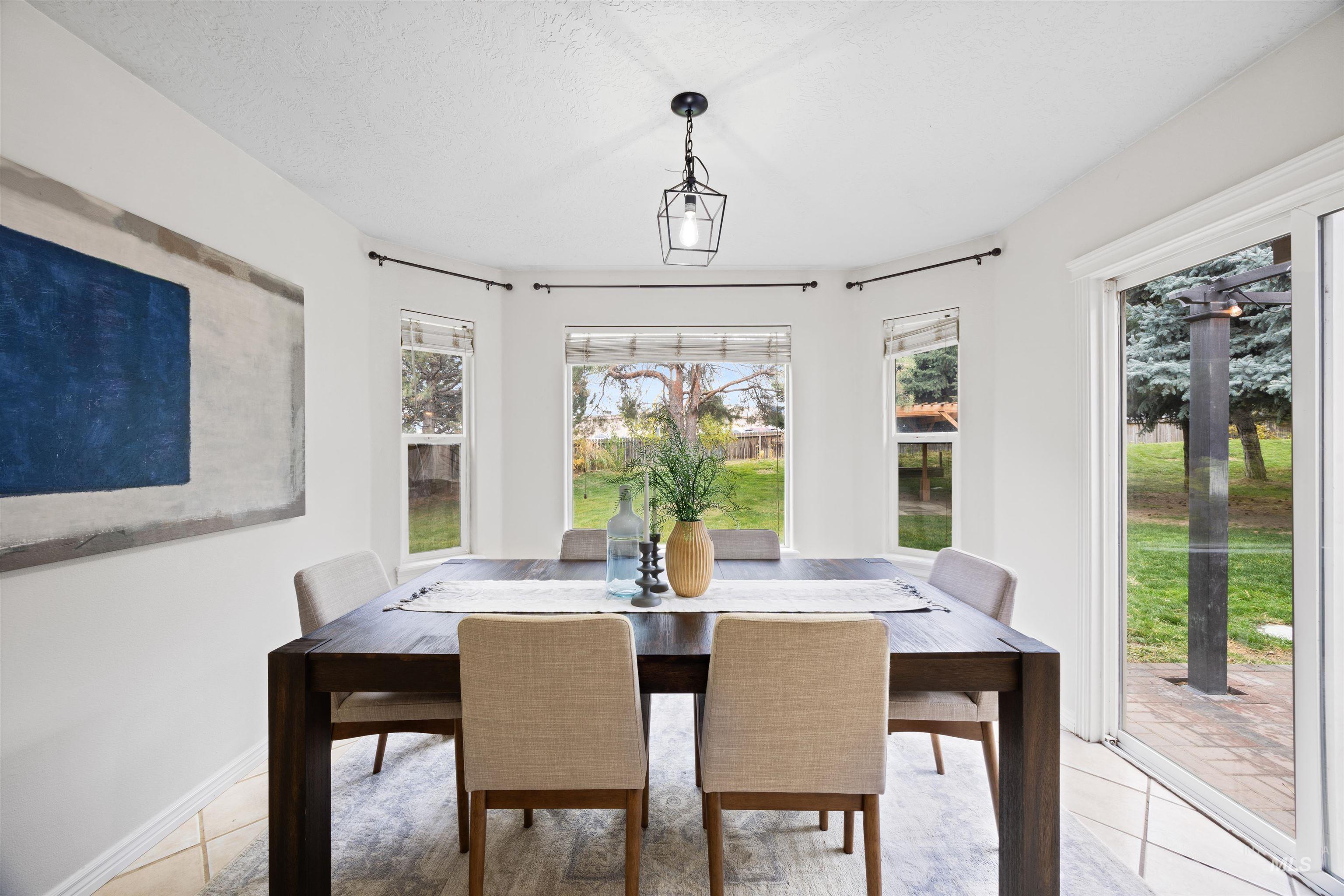 Dining area with light tile patterned floors and a textured ceiling