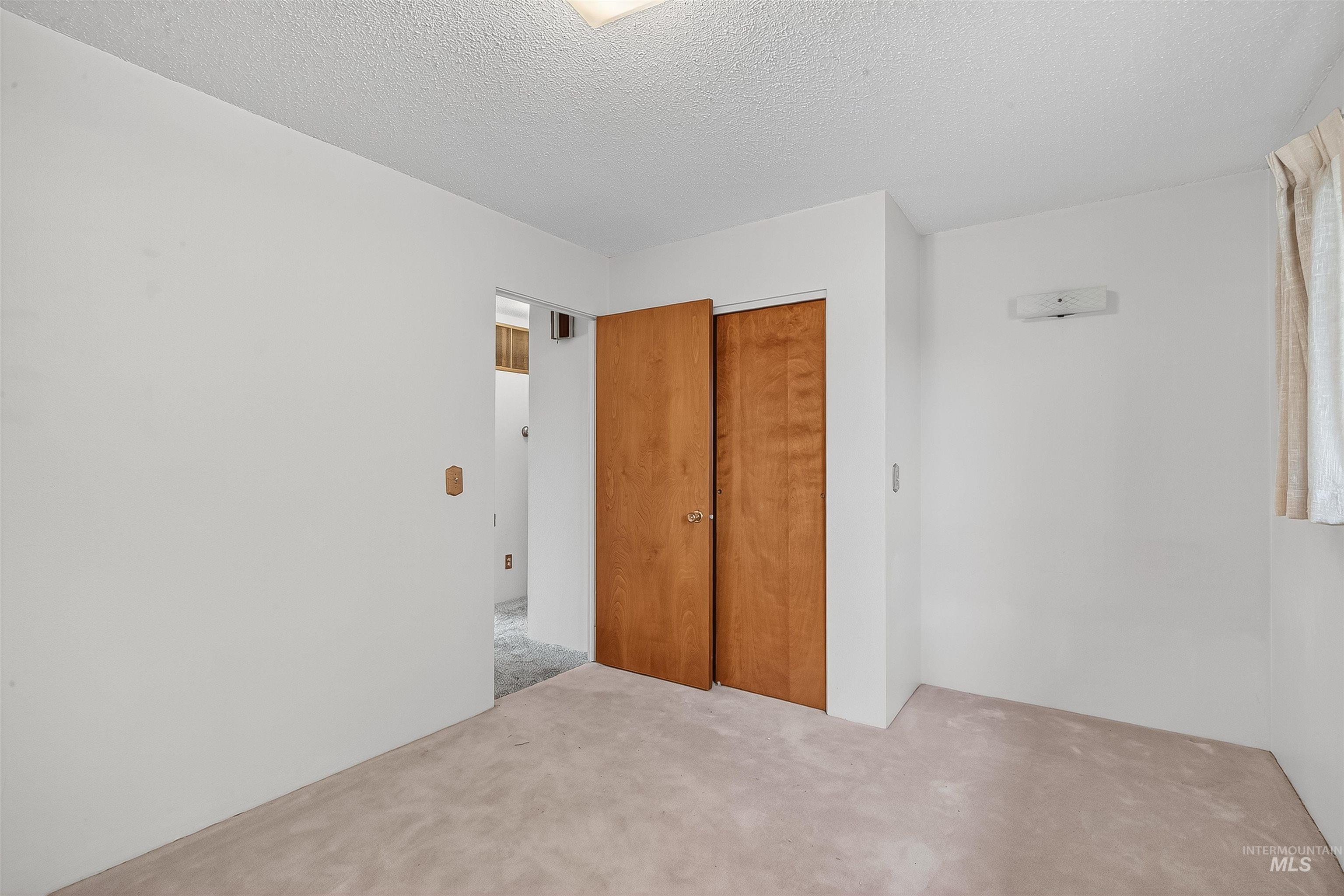 Unfurnished bedroom with carpet floors, a closet, and a textured ceiling