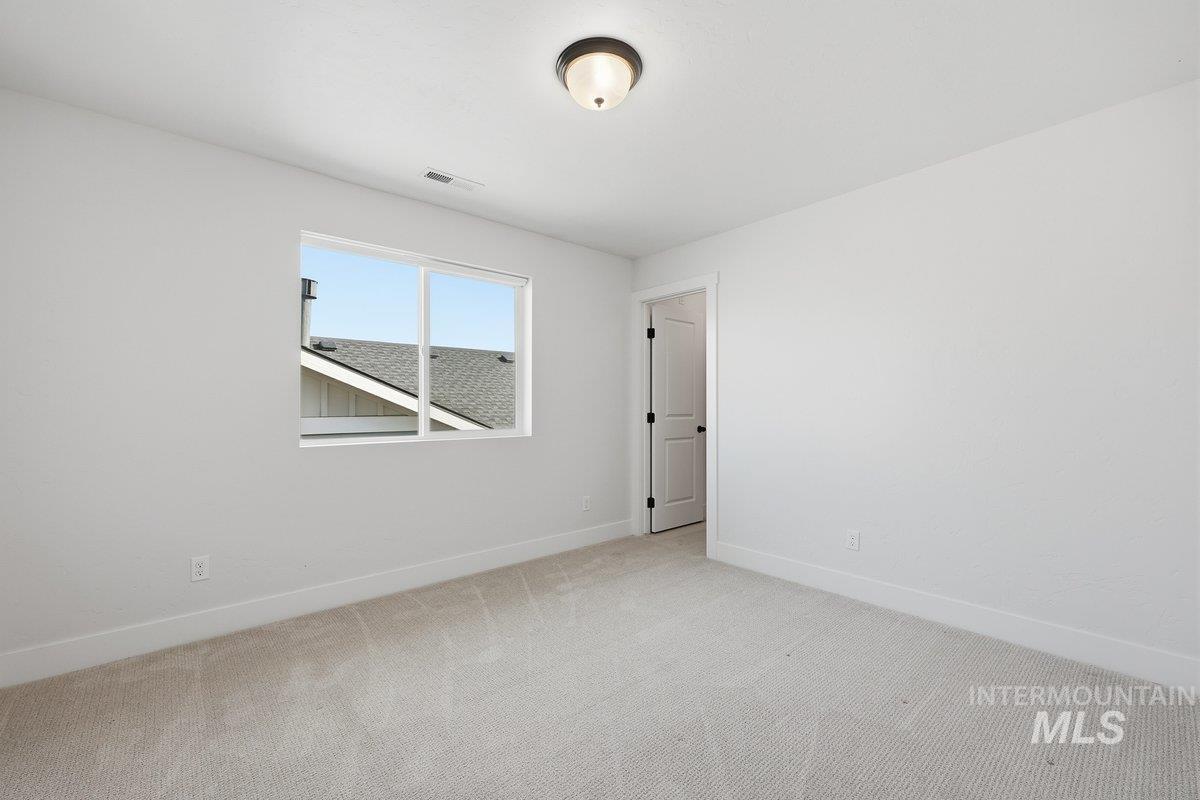 Carpeted empty room featuring baseboards