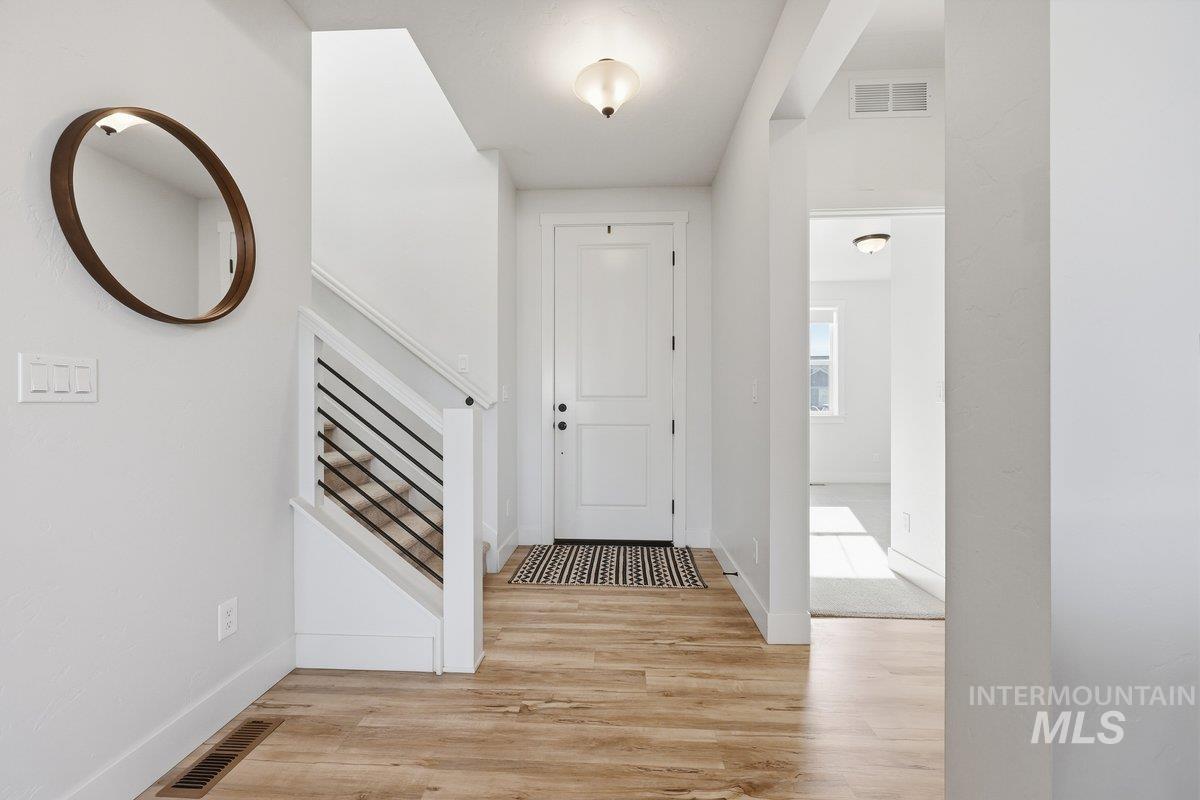 Hall with light wood-style flooring and stairs